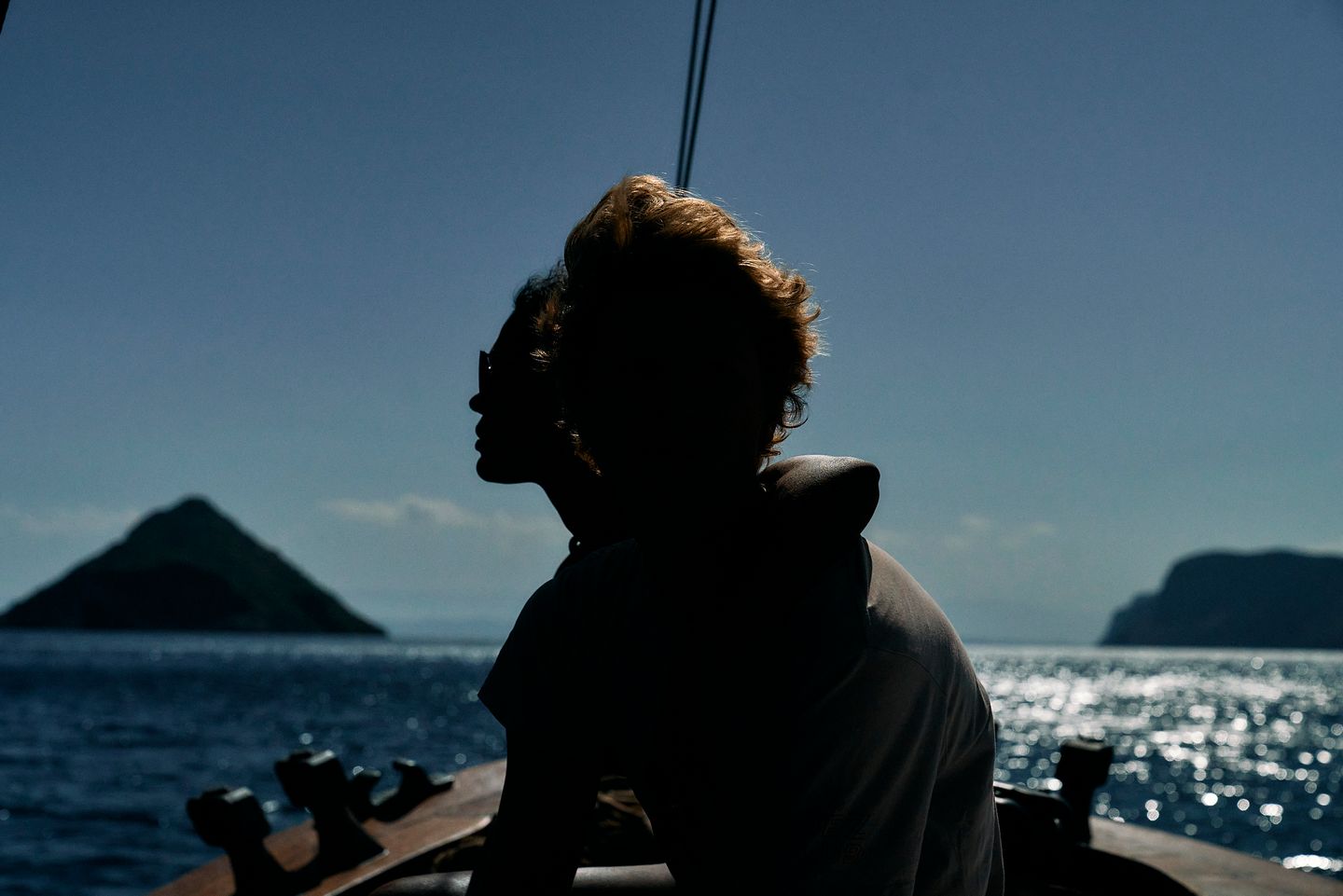 a couple on a boat with a mountain in the background