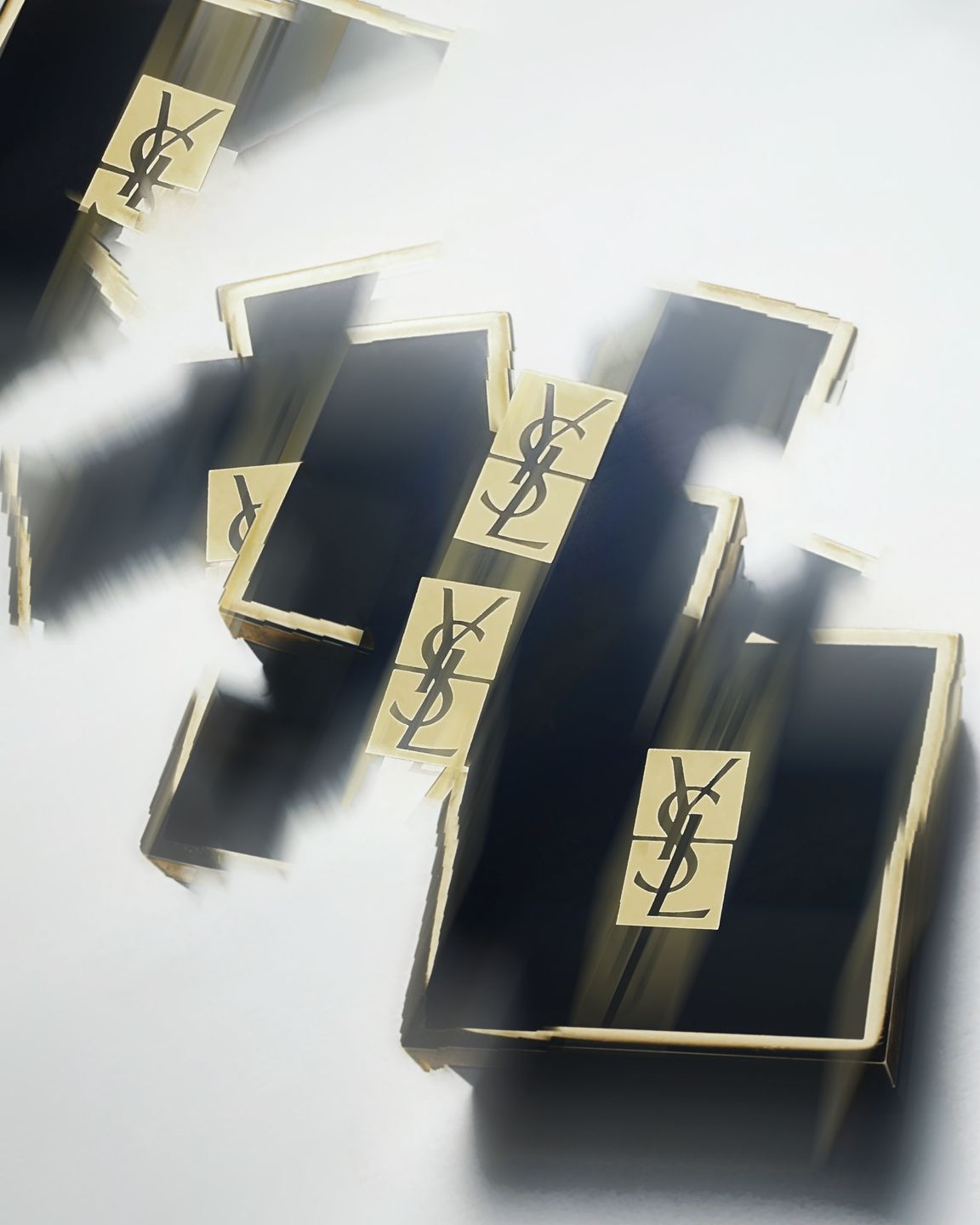 Abstract motion blur of Yves Saint Laurent branded boxes with gold logos, highlighting luxury and movement.