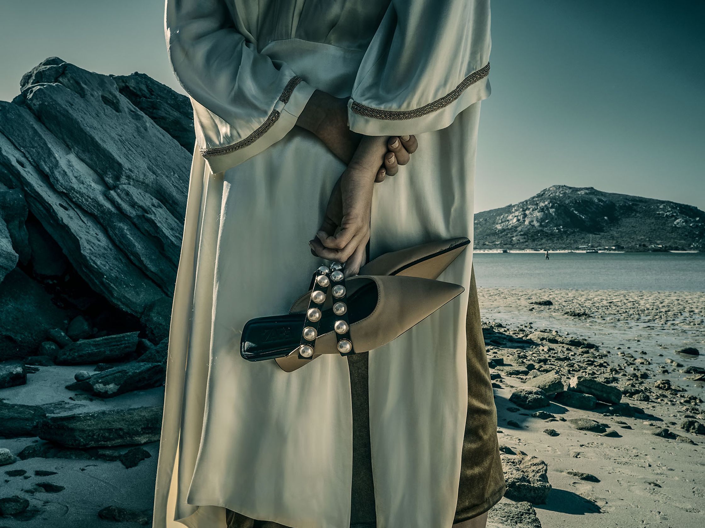 a woman in a robe holding a pair of shoes