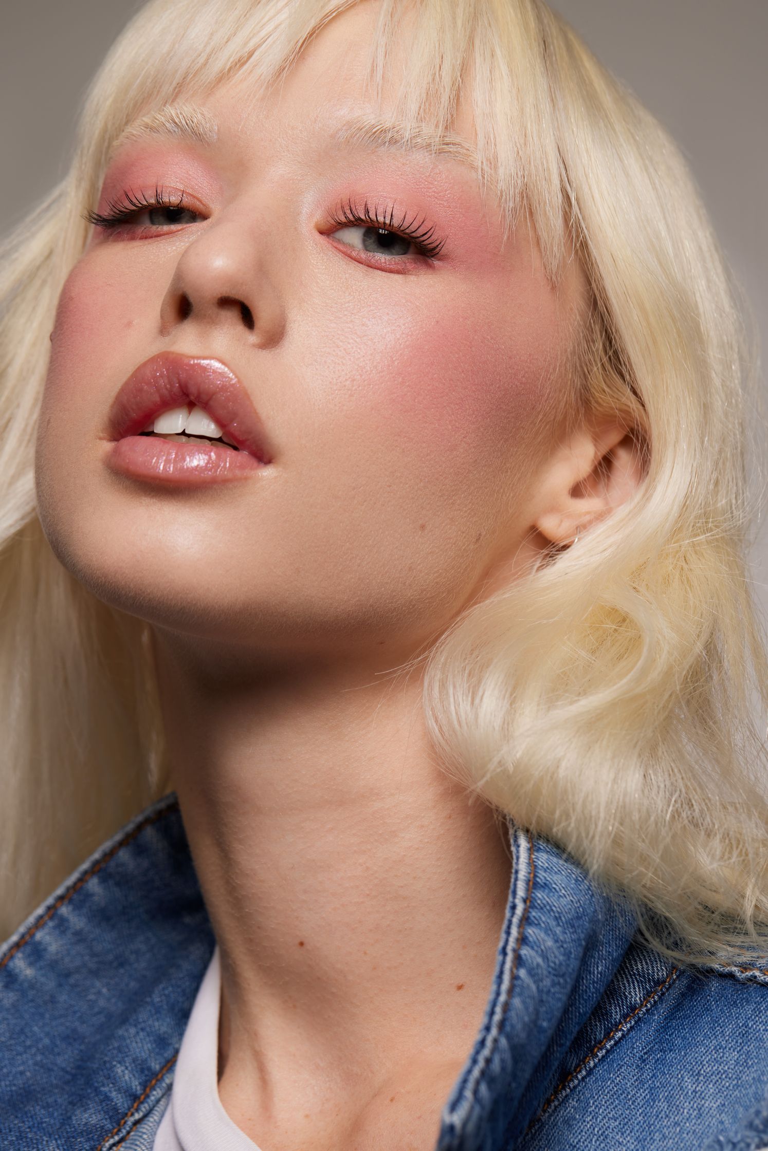 a woman with blond hair and a denim jacket