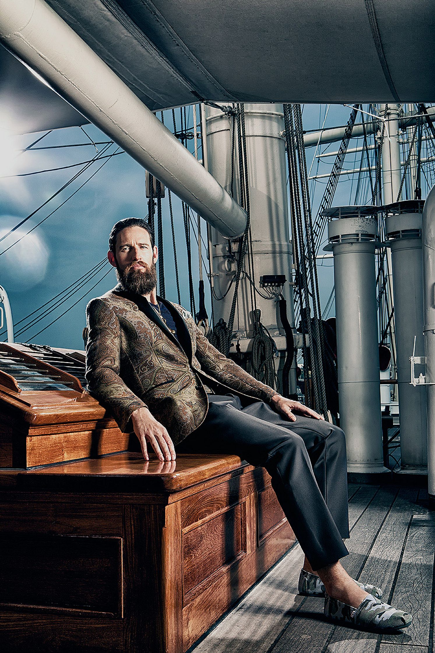 a man with a beard sitting on a wooden bench Creative Retouching Hamburg