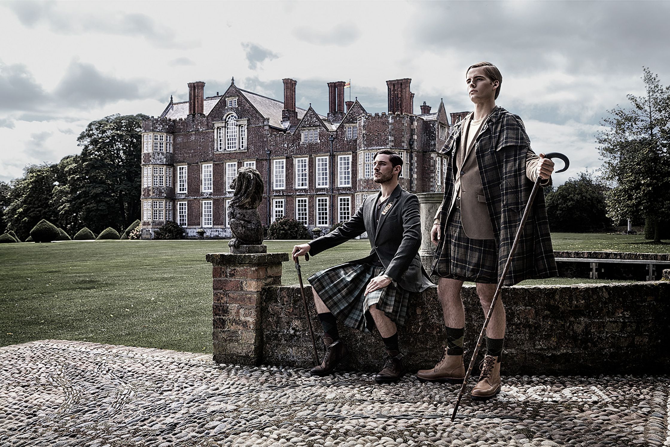 two men in kilts posing in front of a castle creative post production