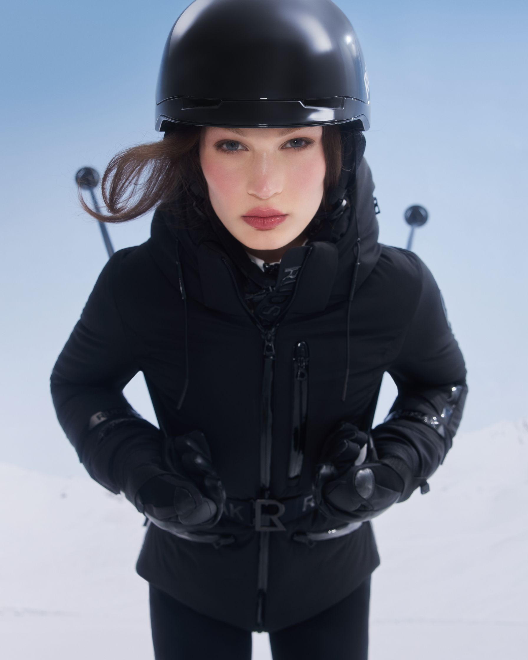 a woman wearing a black ski jacket and helmet