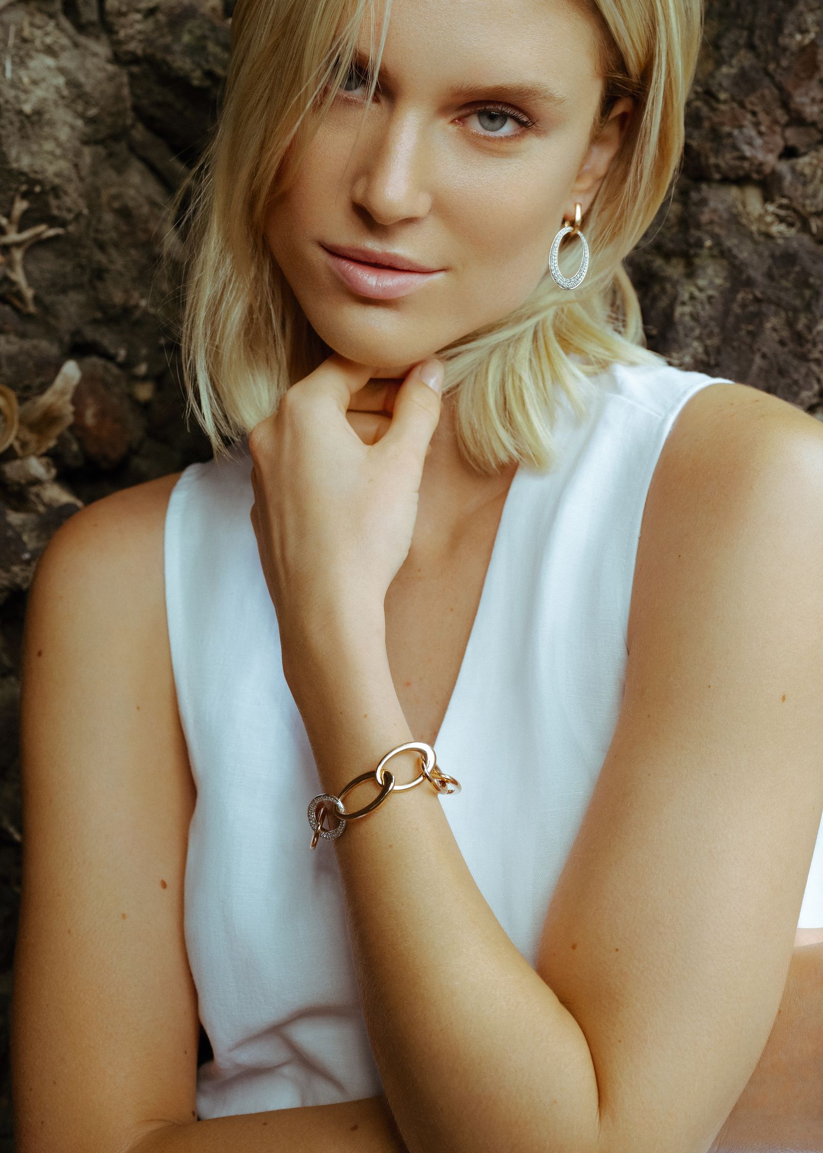 a woman wearing a white top and a bracelet