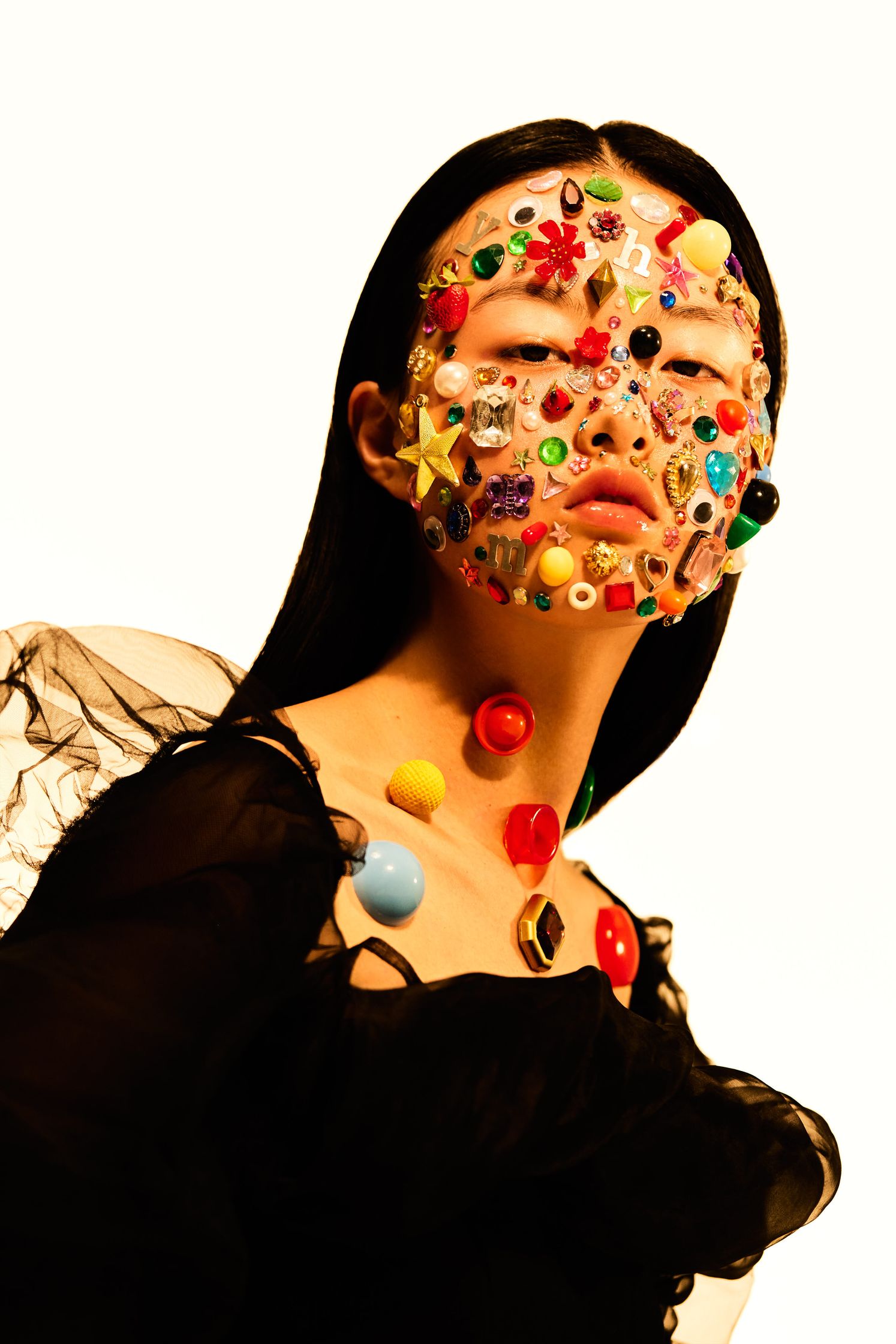 a woman in a black dress with a lot of buttons on her face