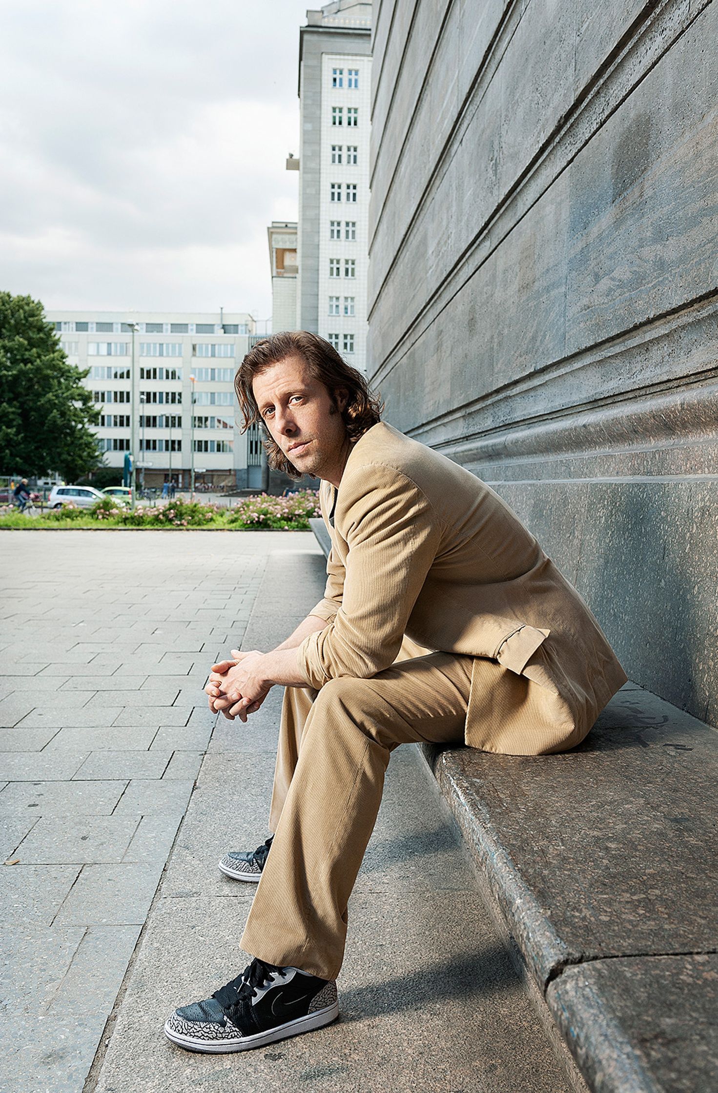 oliver korittke in a tan suit sitting on a bench
retusche by glamtouch