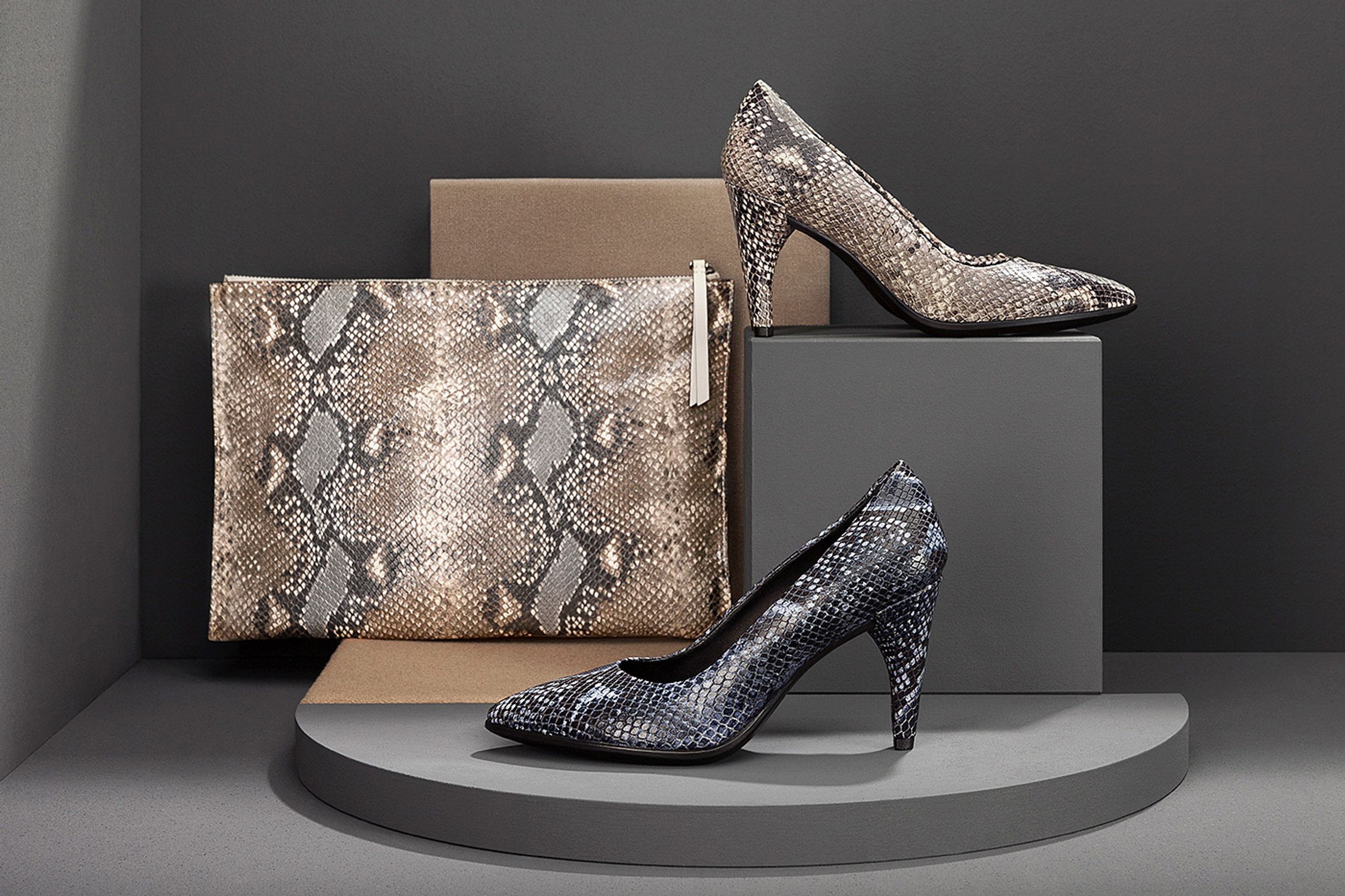 a pair of snake skin shoes and a bag on a pedestal - Retouch - Bildbearbeitung Hamburg