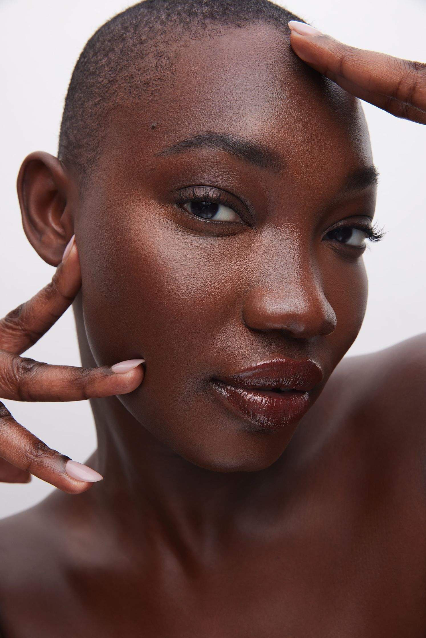 a black woman posing with her hands on her face