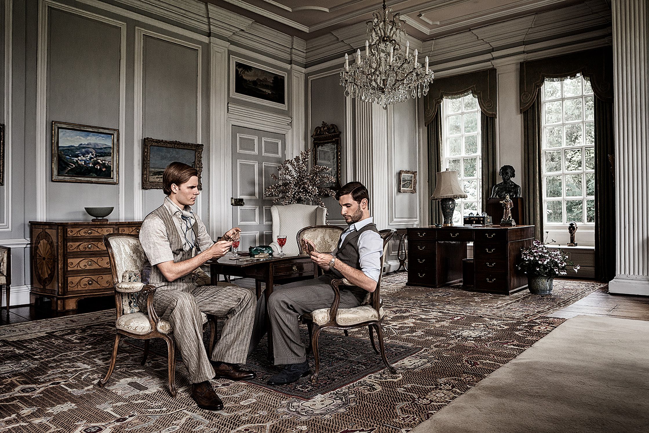 two men sitting in a room playing cards creative post production