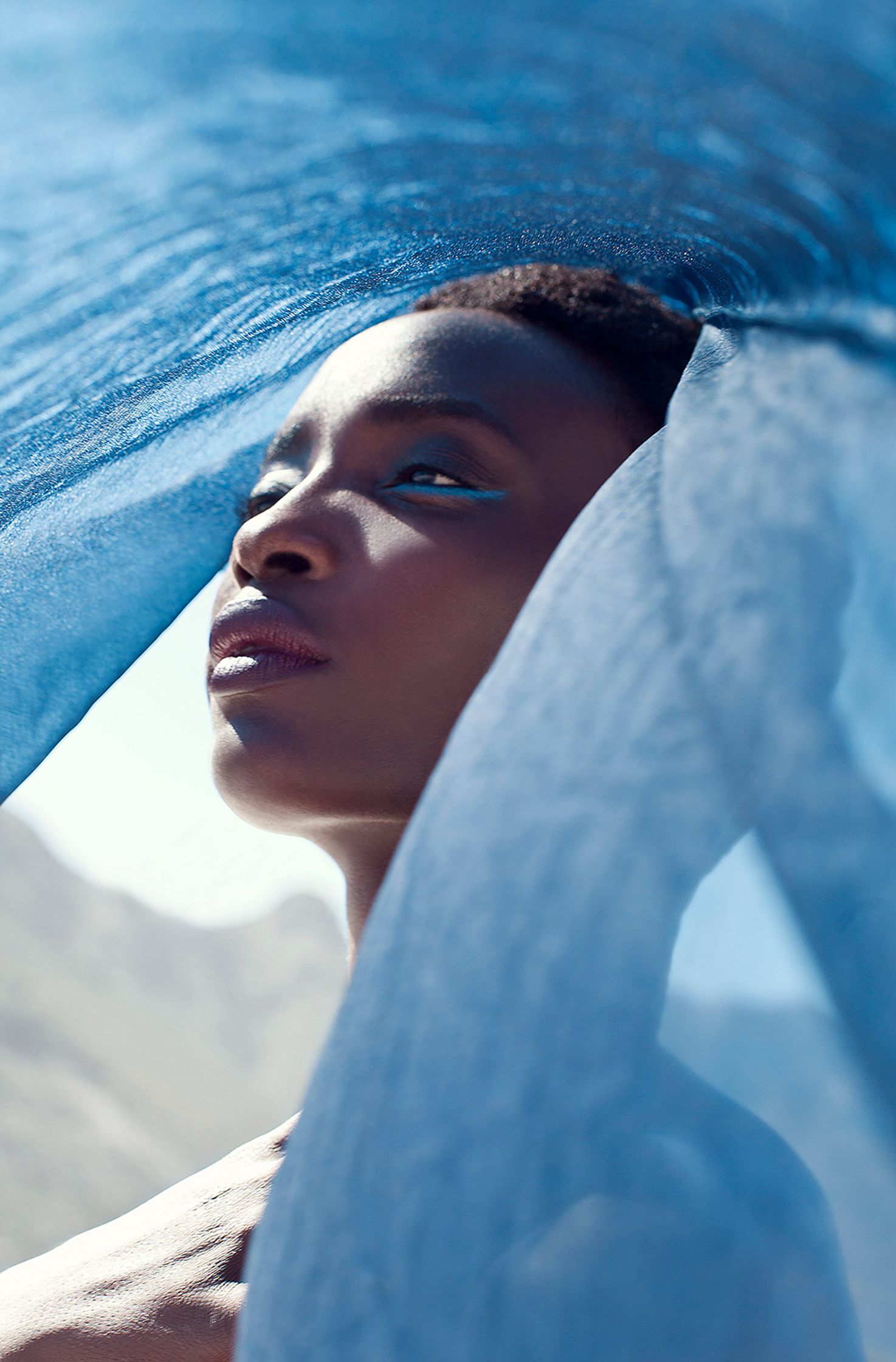 a black woman under a blue umbrella skin retouch