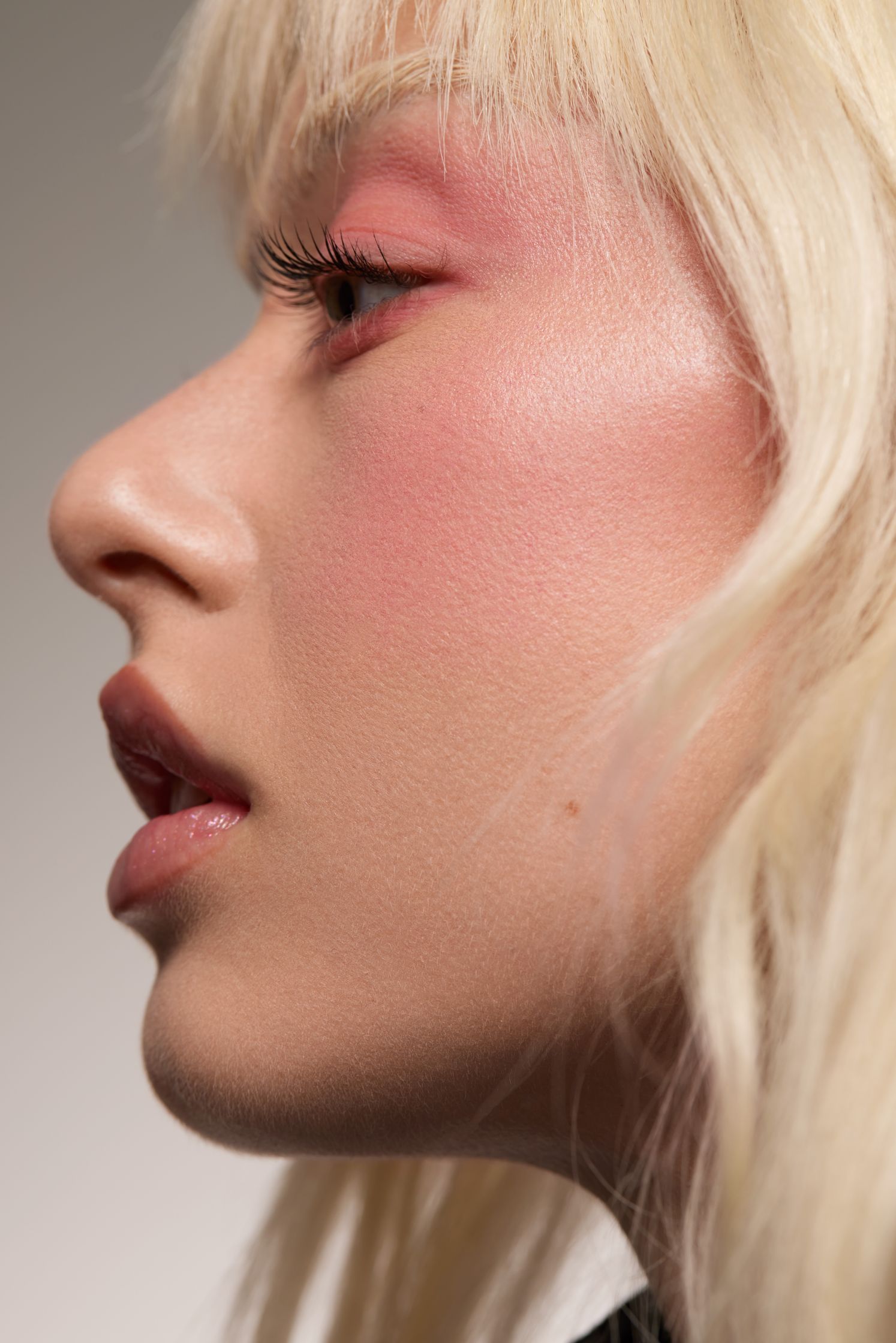 a close up of a woman with blond hair and pink makeup