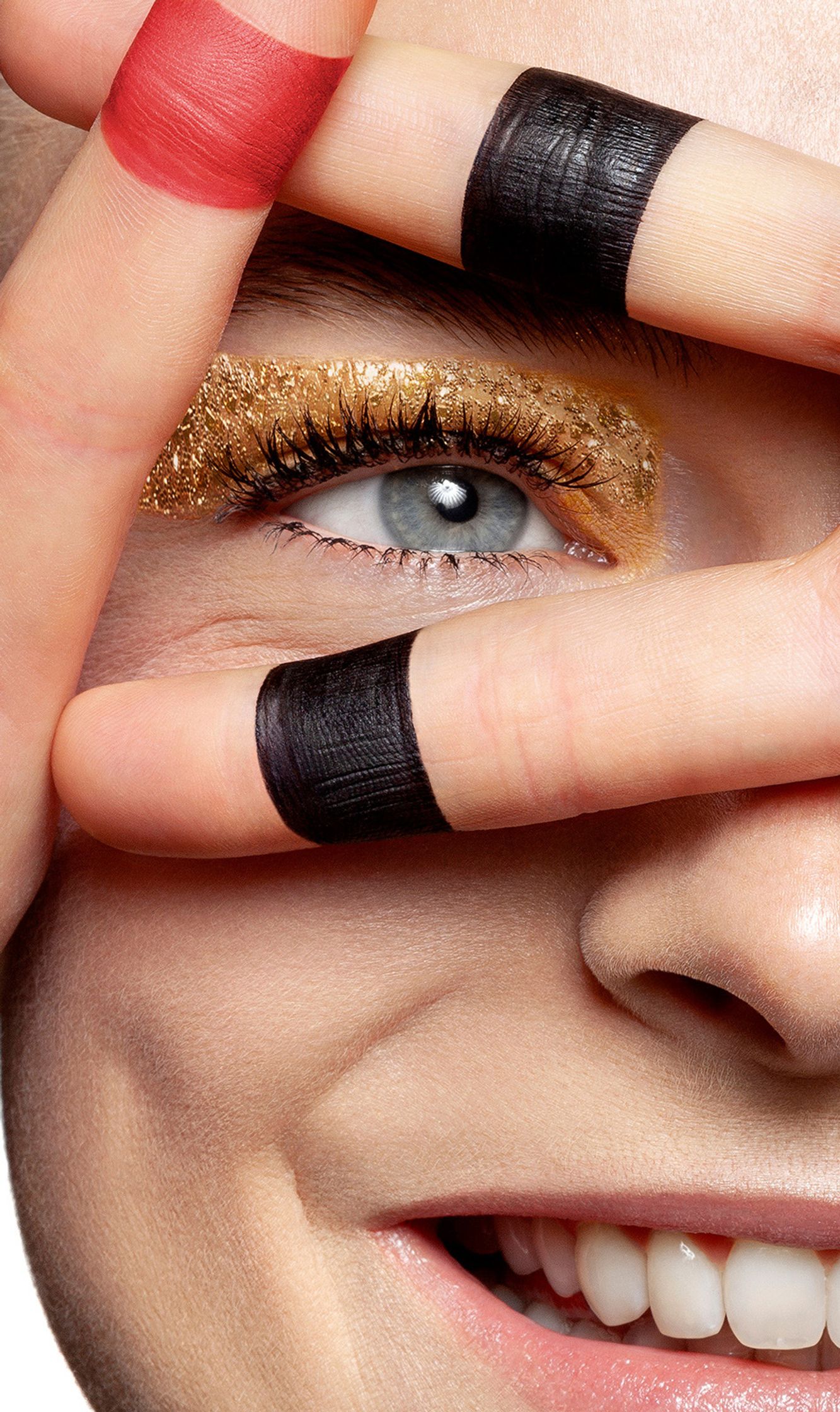 a woman's face with black and gold makeup on her eyes beauty post production