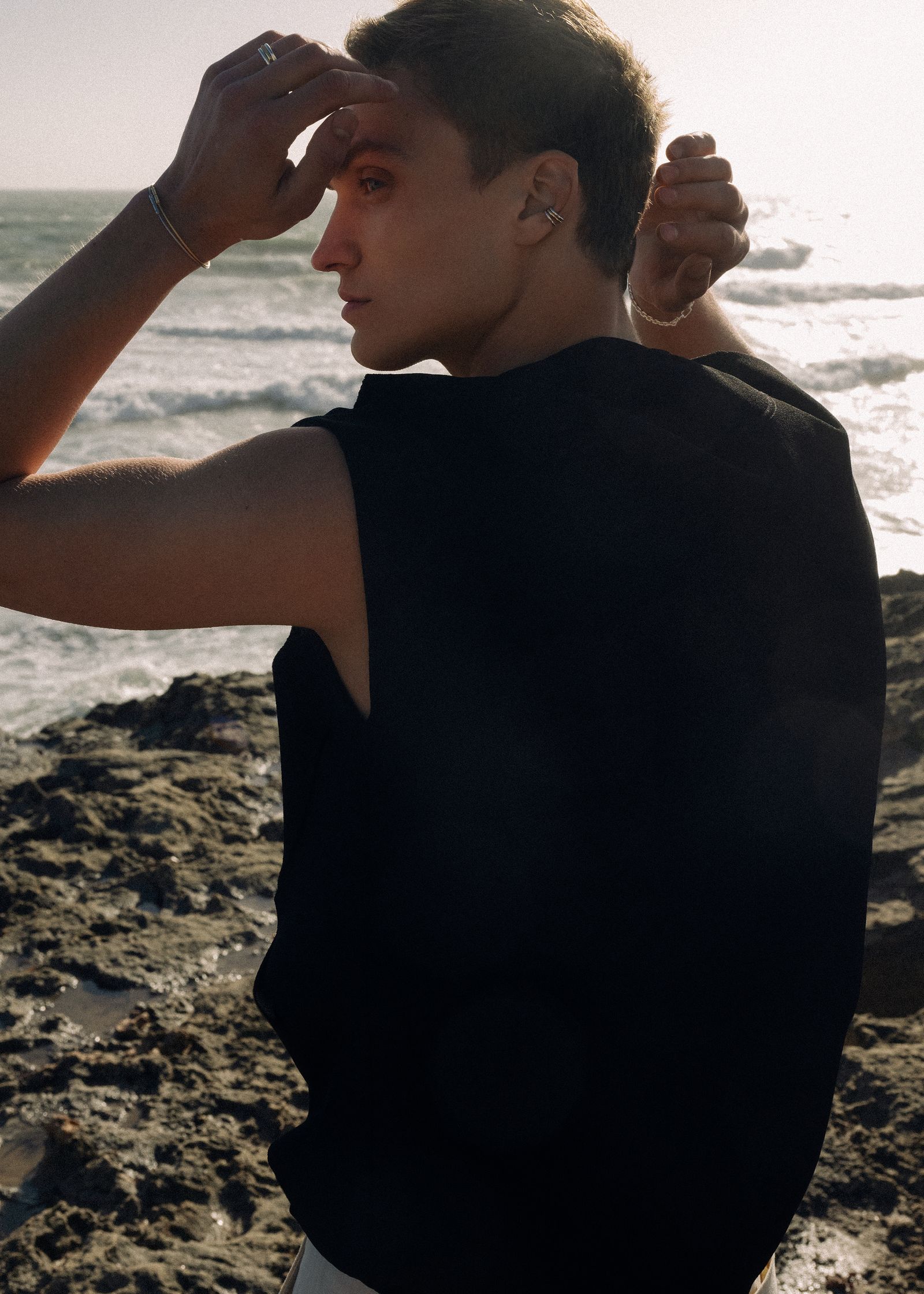 a man standing on a rocky beach looking at the ocean