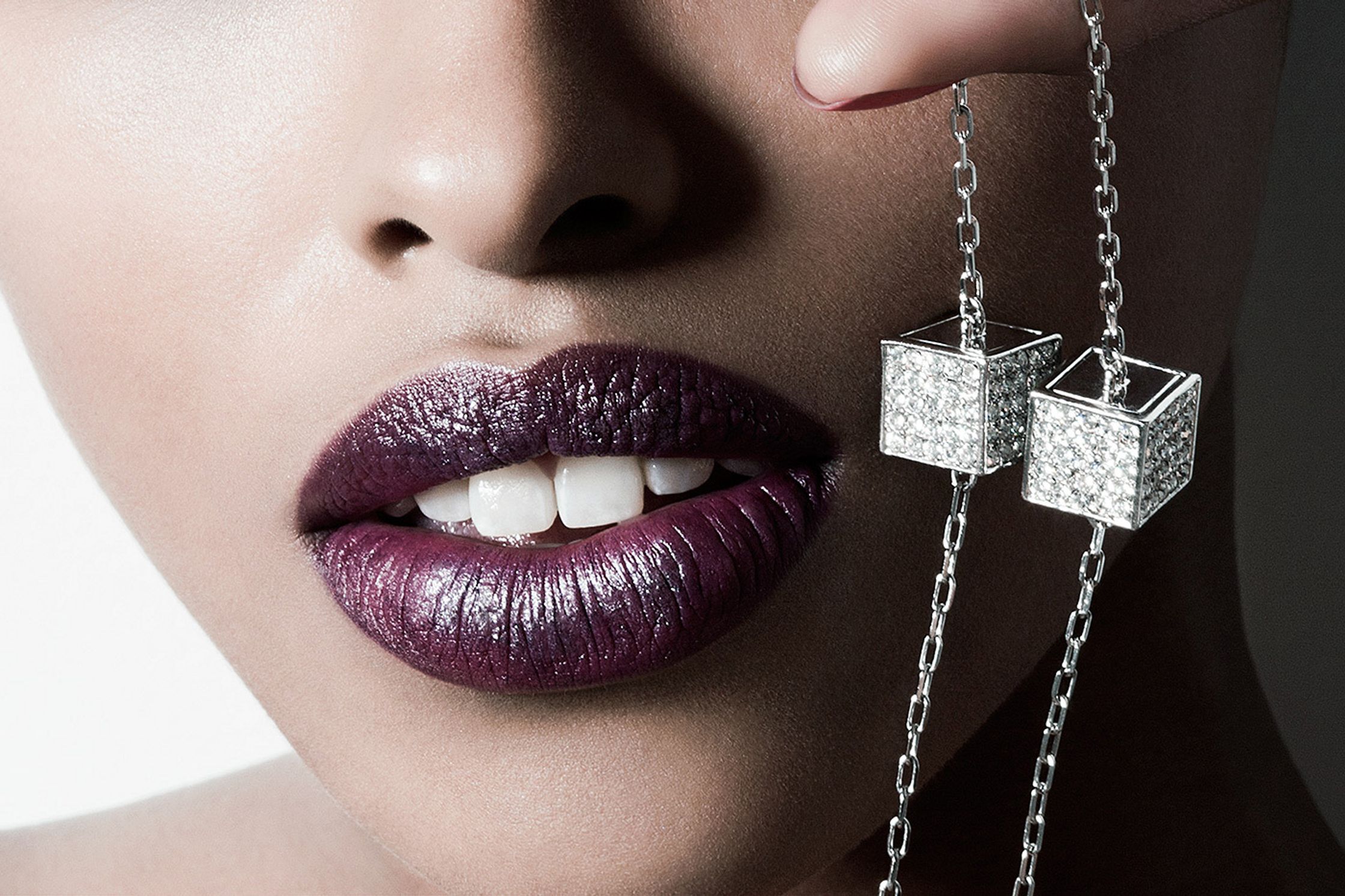 a woman with purple lips holding a necklace beauty post production