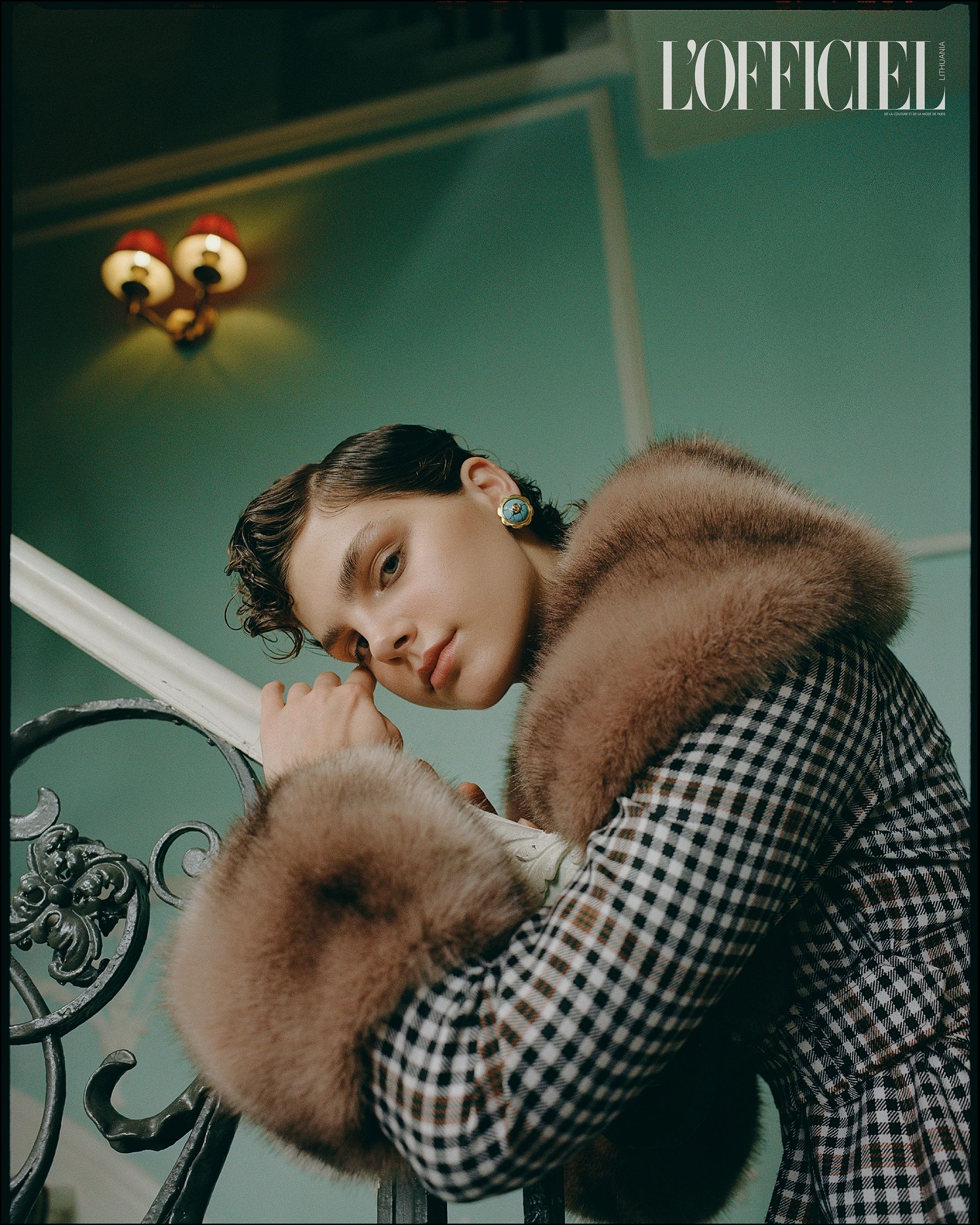 a woman in a fur coat leaning against a railing