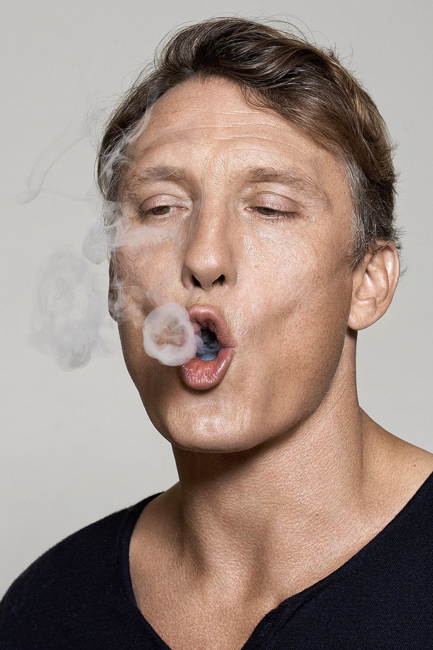 oliver masucci is smoking a cigarette with his mouth open
Bildbearbeitung by glamtouch