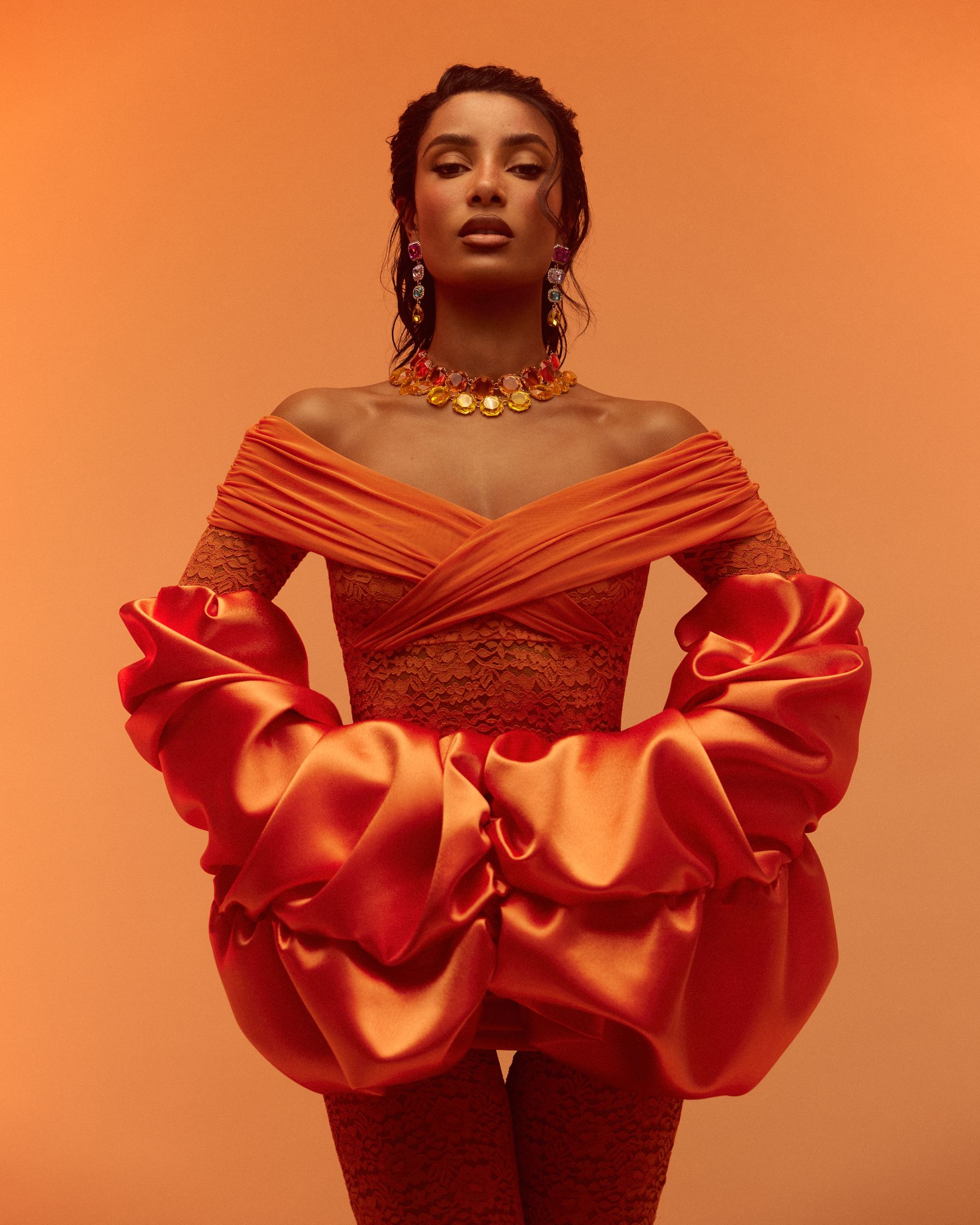 a woman in an orange dress posing for a photo