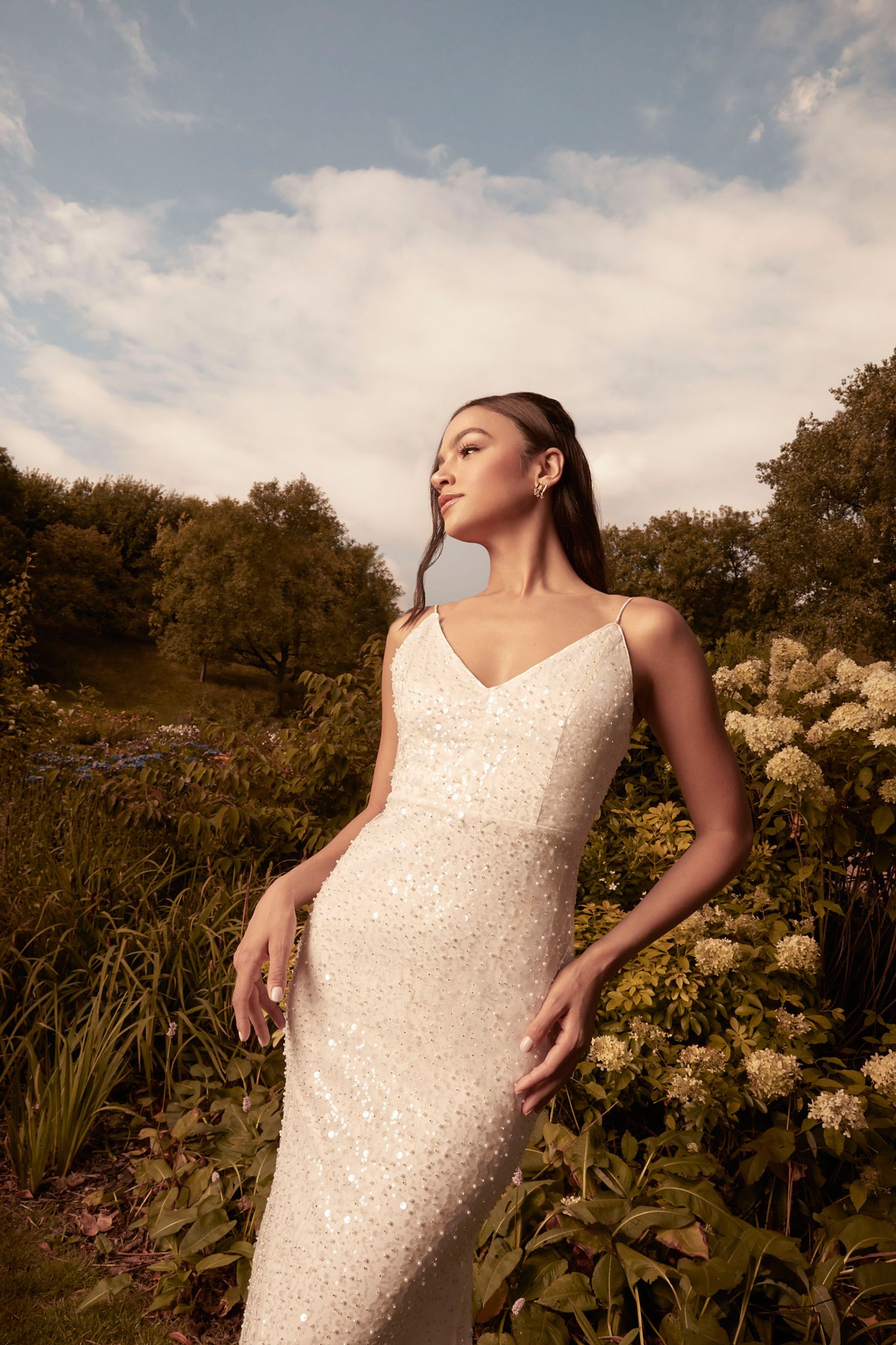 a woman in a white wedding dress posing in a field