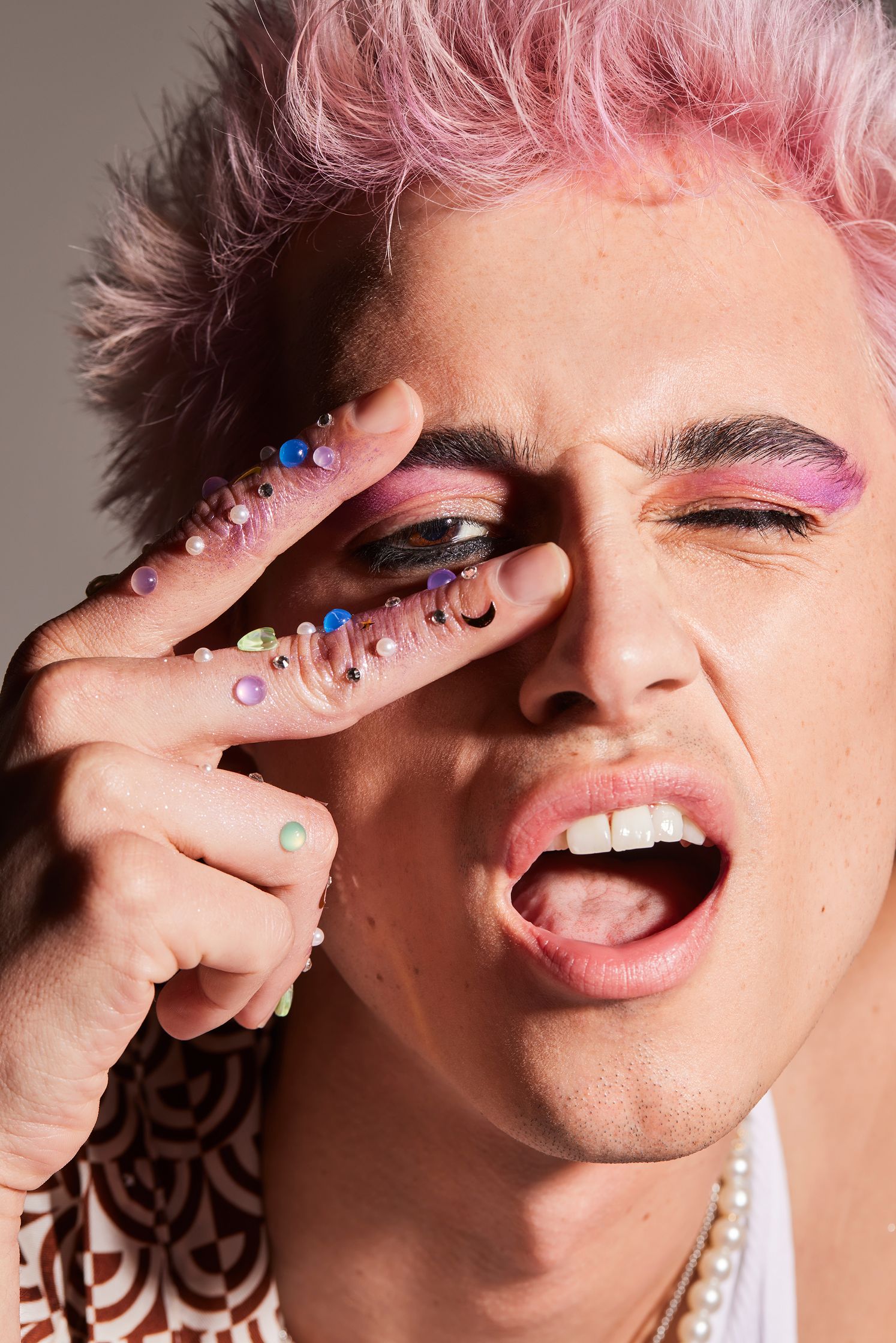 a young man with pink hair and makeup on his face