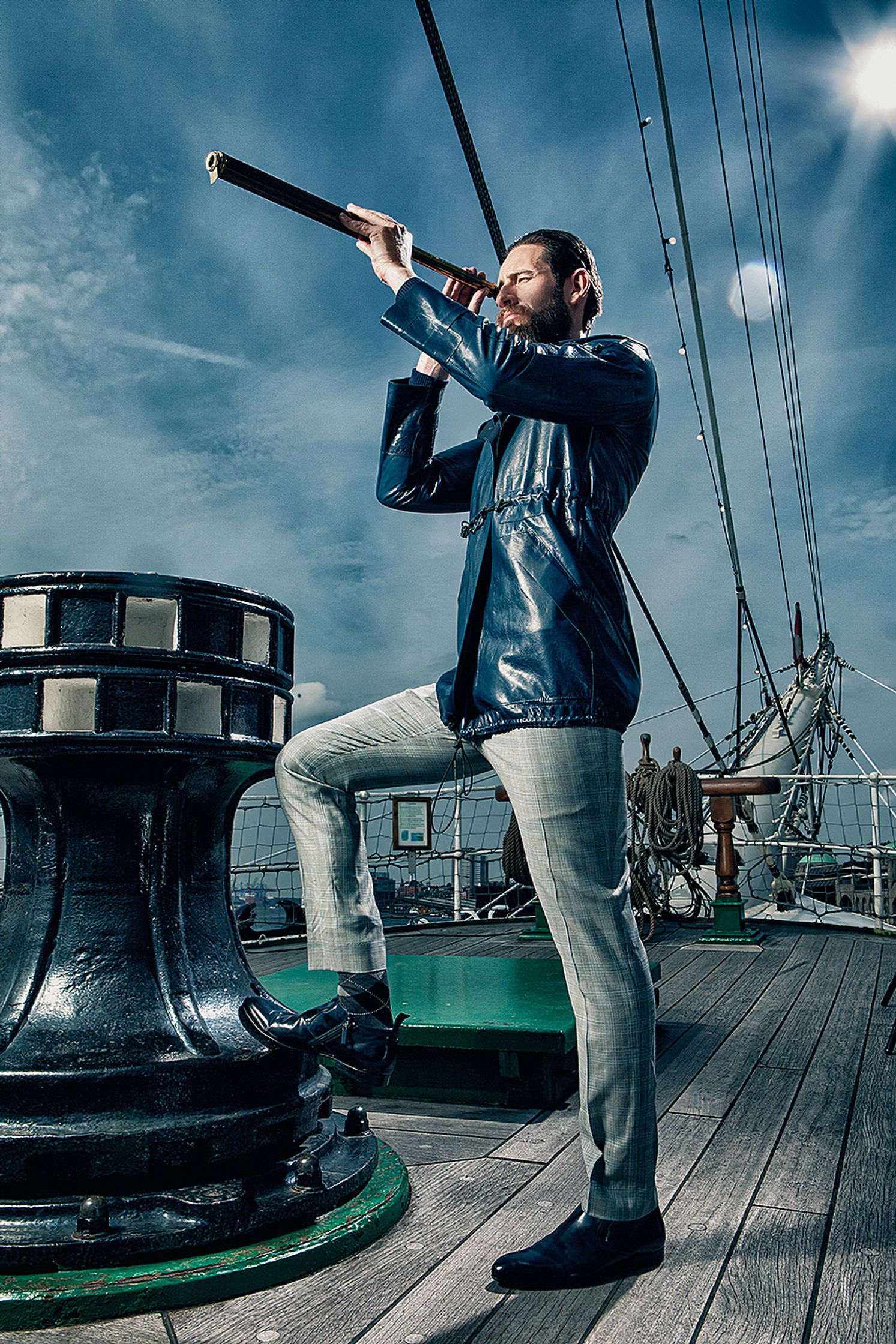 a man holding a telescope on a deck Creative Retouching Hamburg