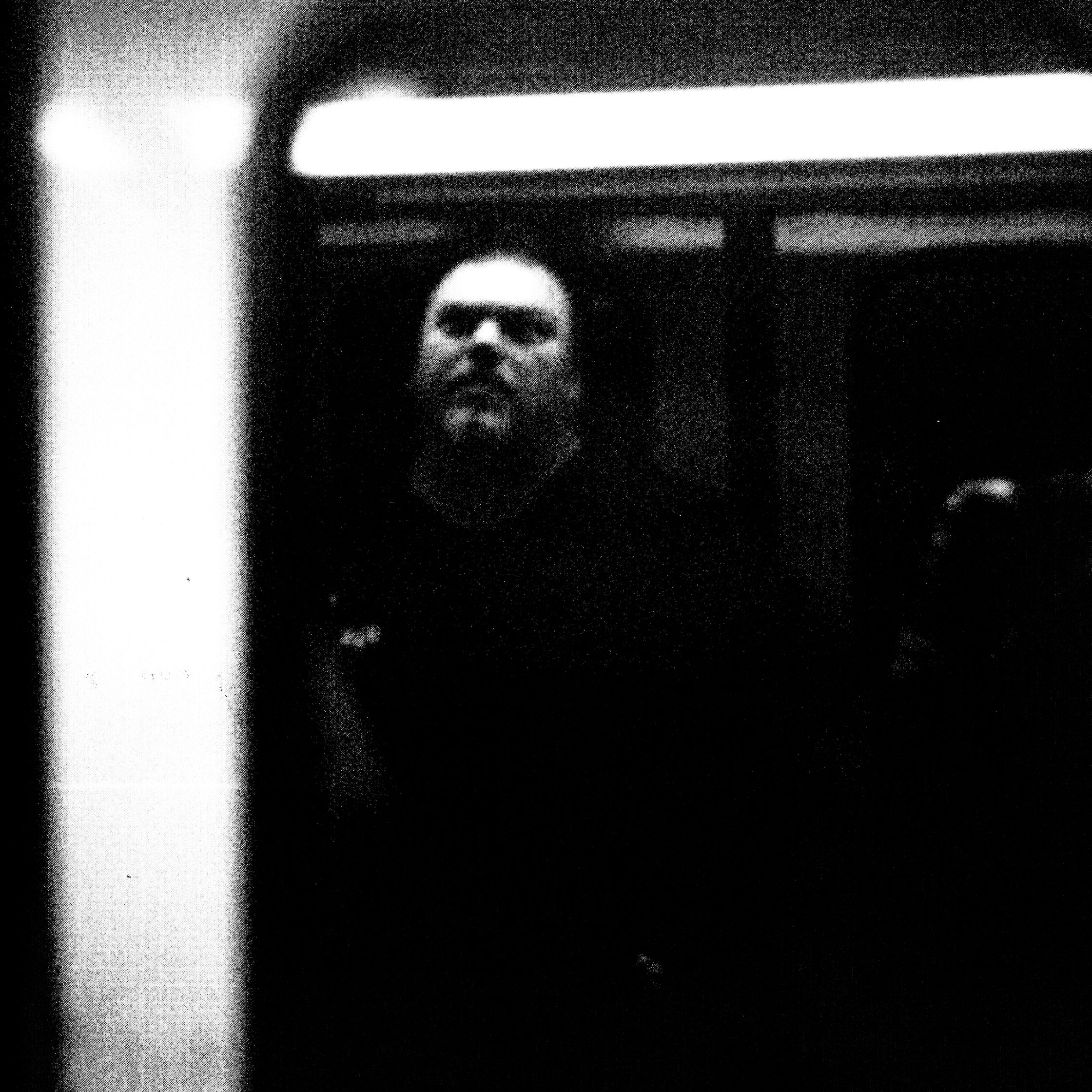 a black and white photo of a man on a train