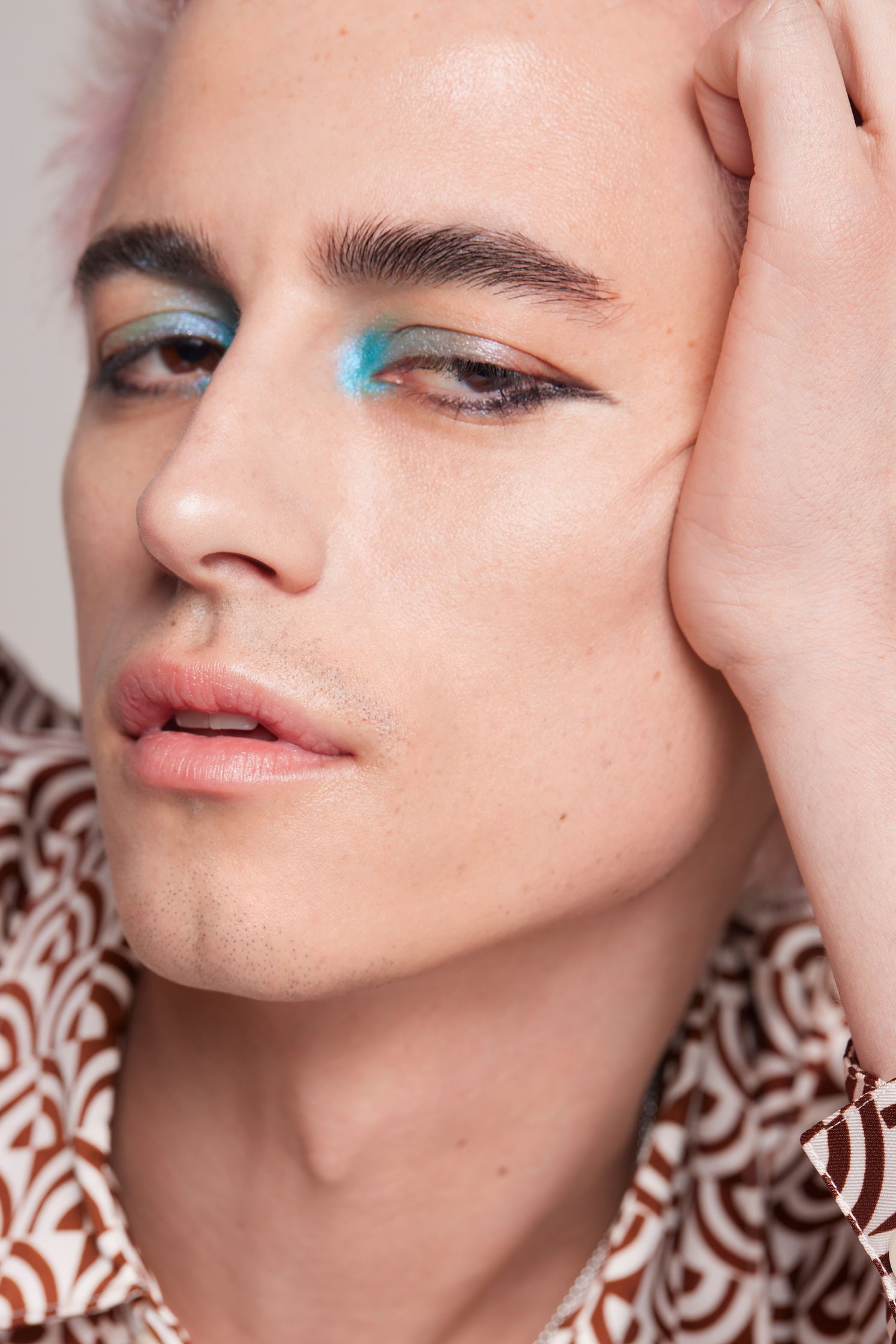 a man with pink hair and blue eyes posing for a photo