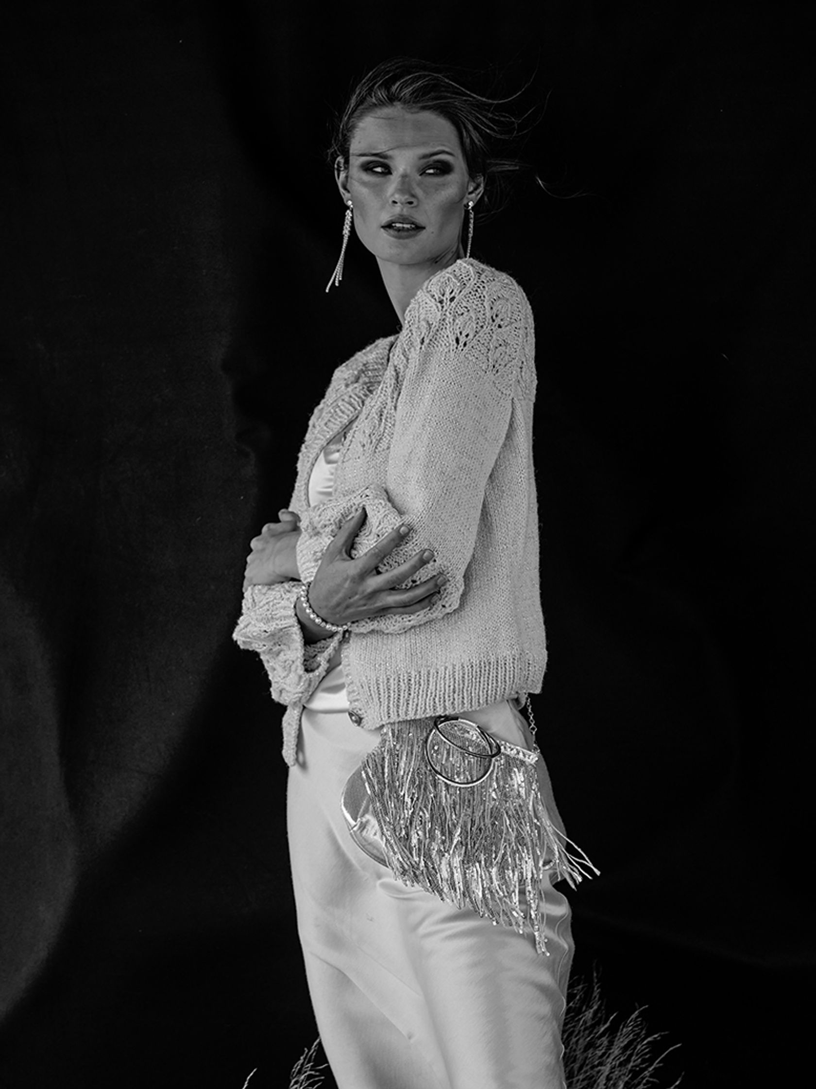 a black and white photo of a woman in a sweater and pants