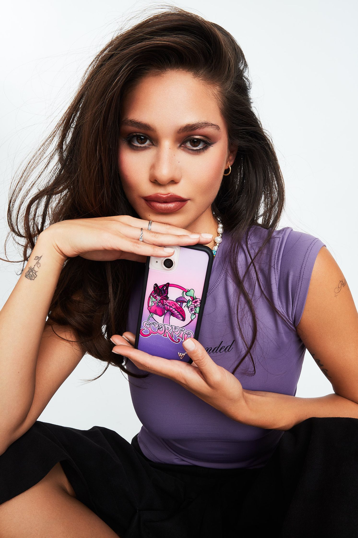 a woman holding up a phone case with a pink and purple design