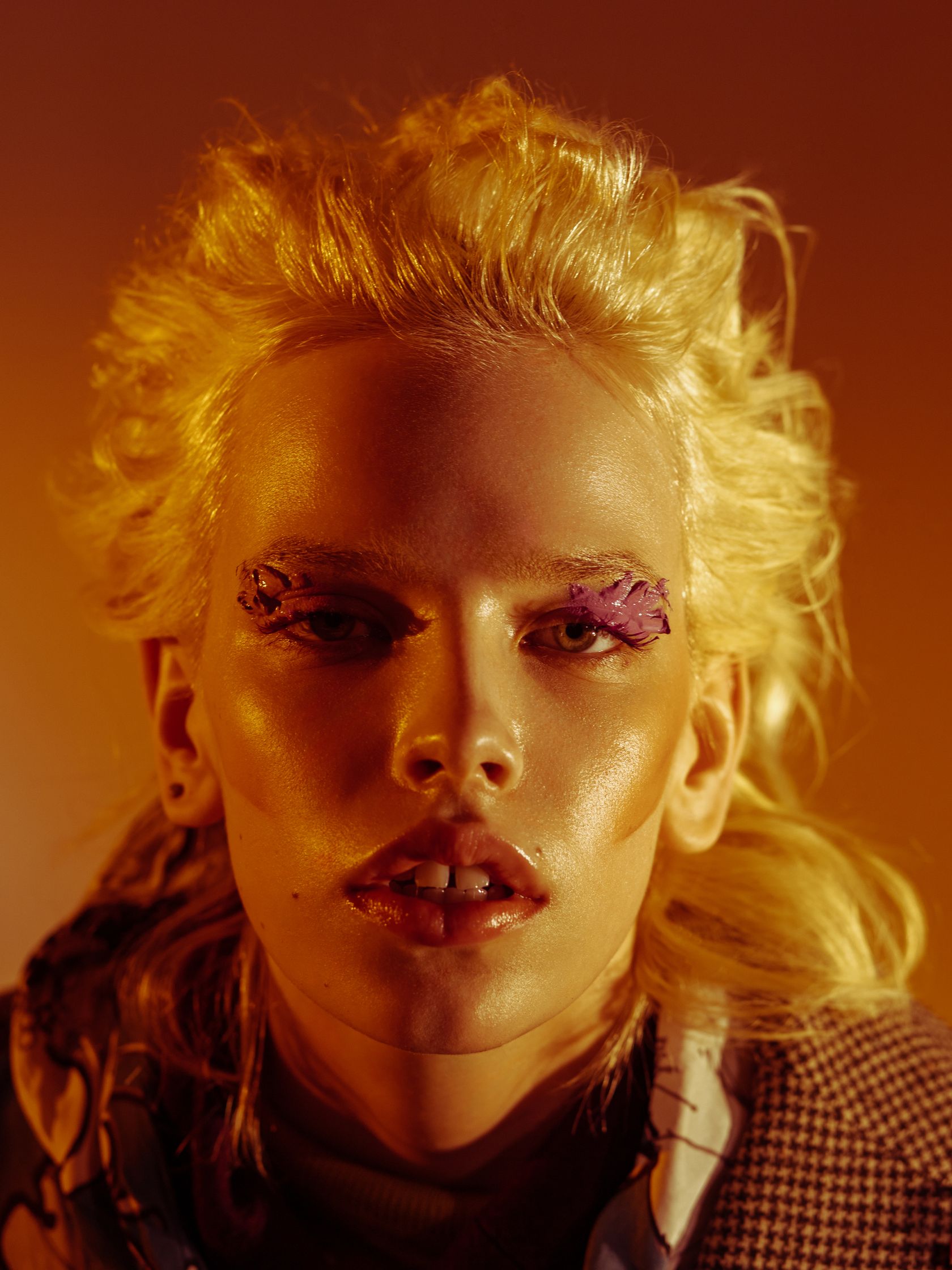 a woman with blond hair and purple eye makeup