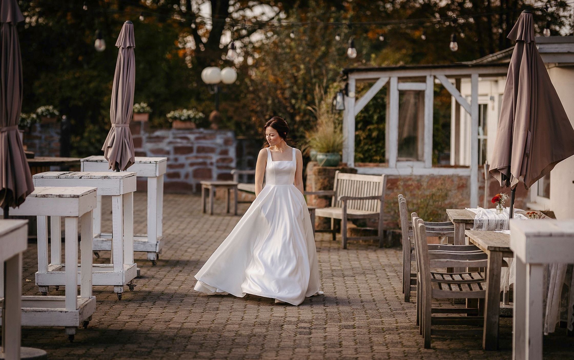 Eine Braut in einem weißen Kleid, die auf einer Terrasse spaziert