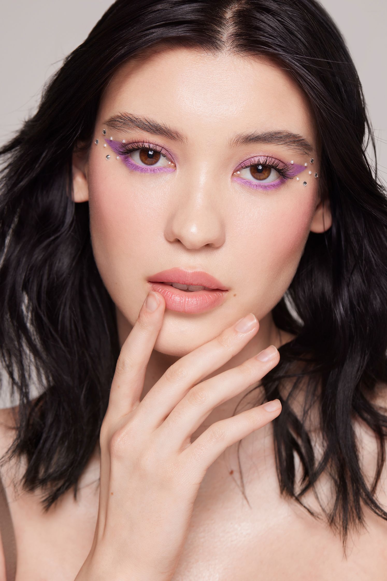 a woman with purple eye makeup posing for a photo