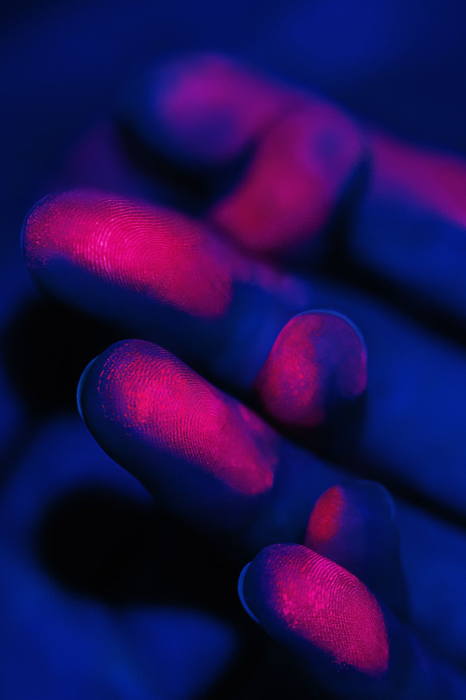 a person's hand with pink and blue paint on it post production