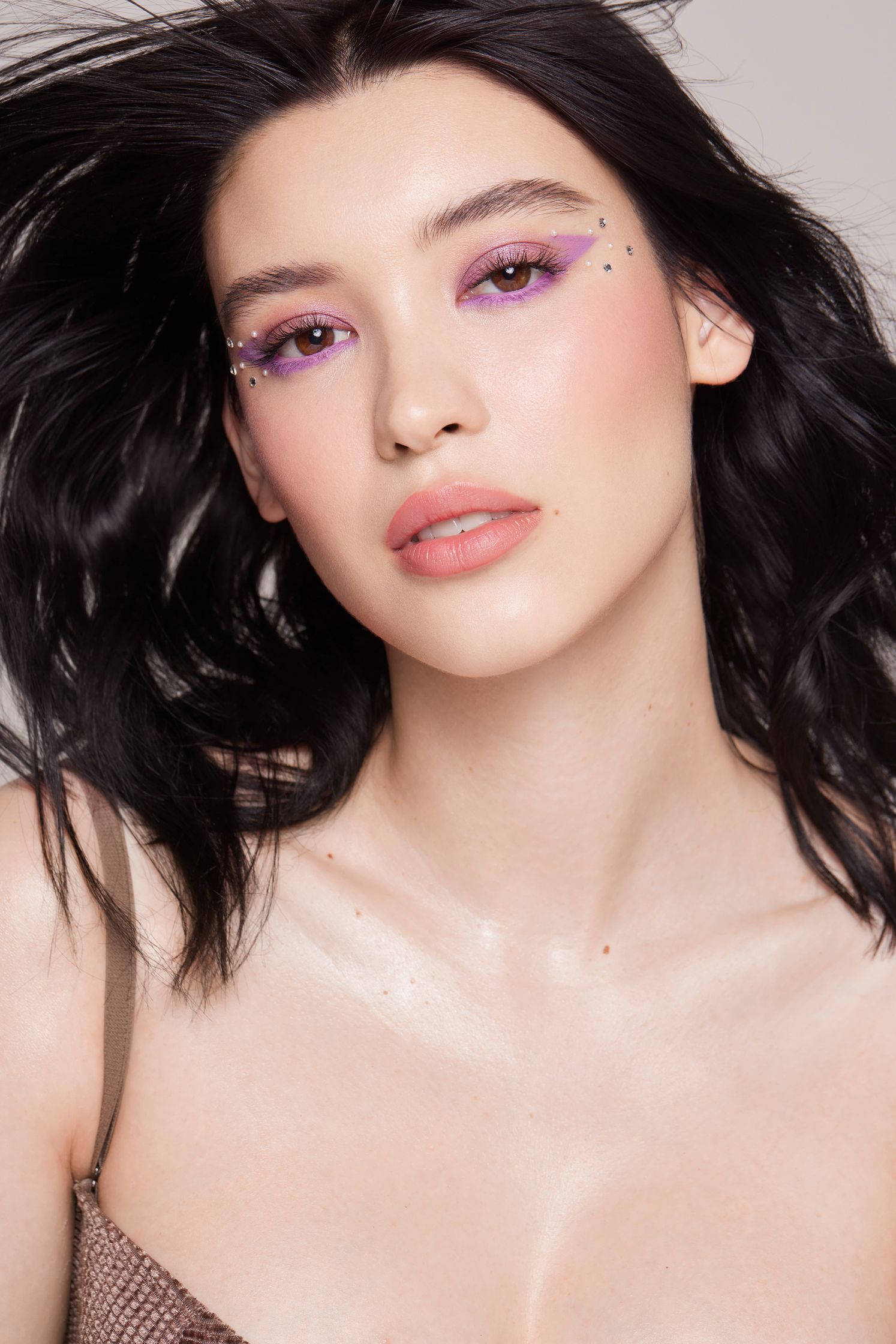 a woman with long black hair and purple eyeshadow