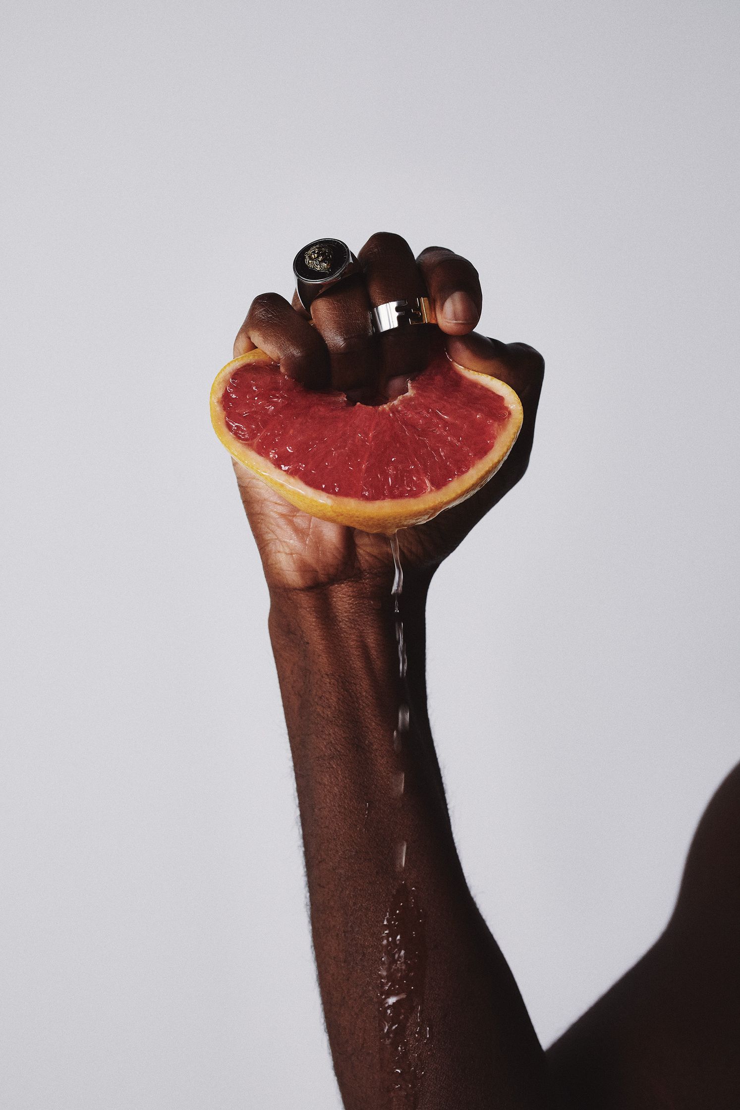 a man is holding a grapefruit in his hand