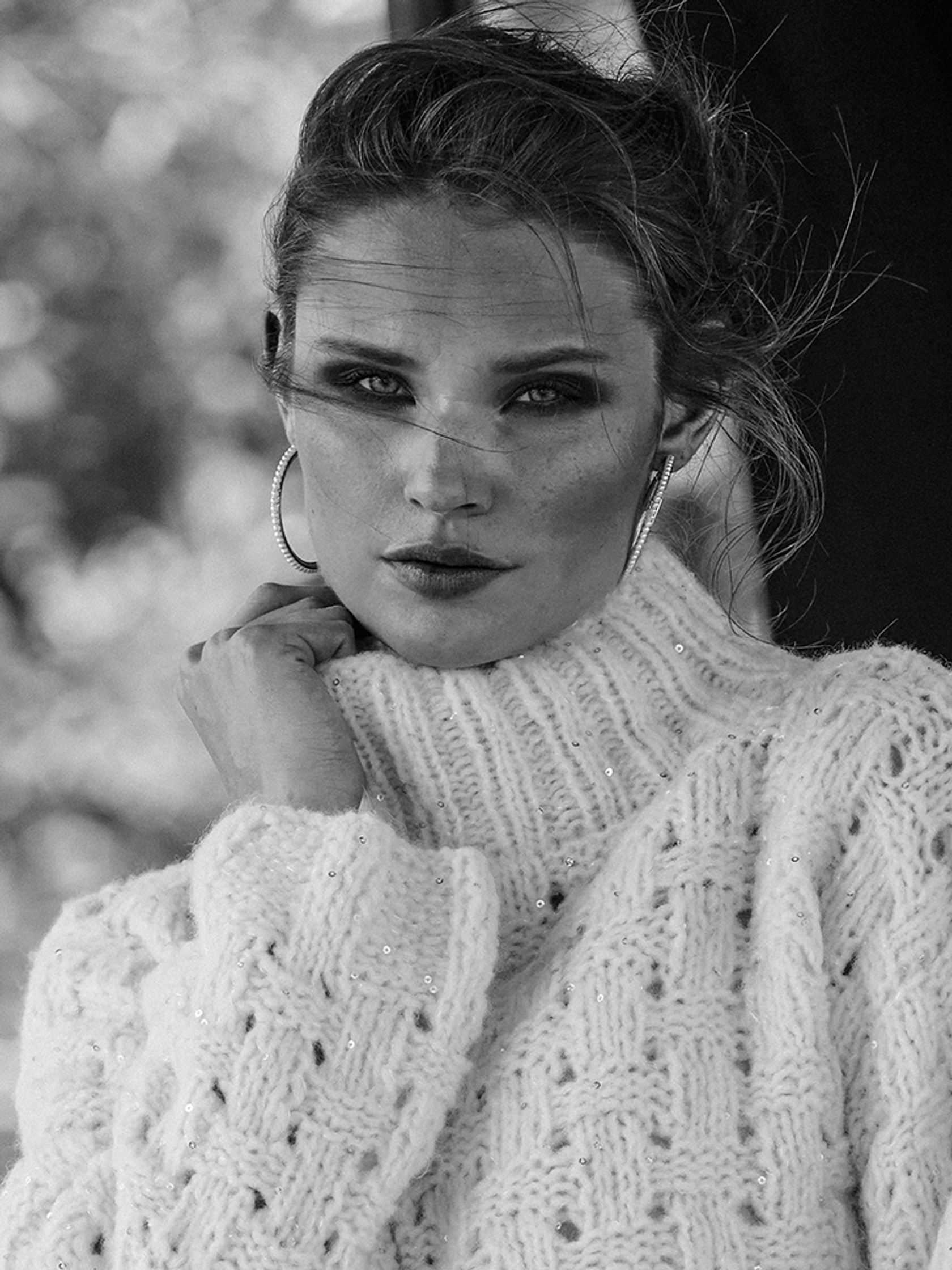 a black and white photo of a woman wearing a sweater