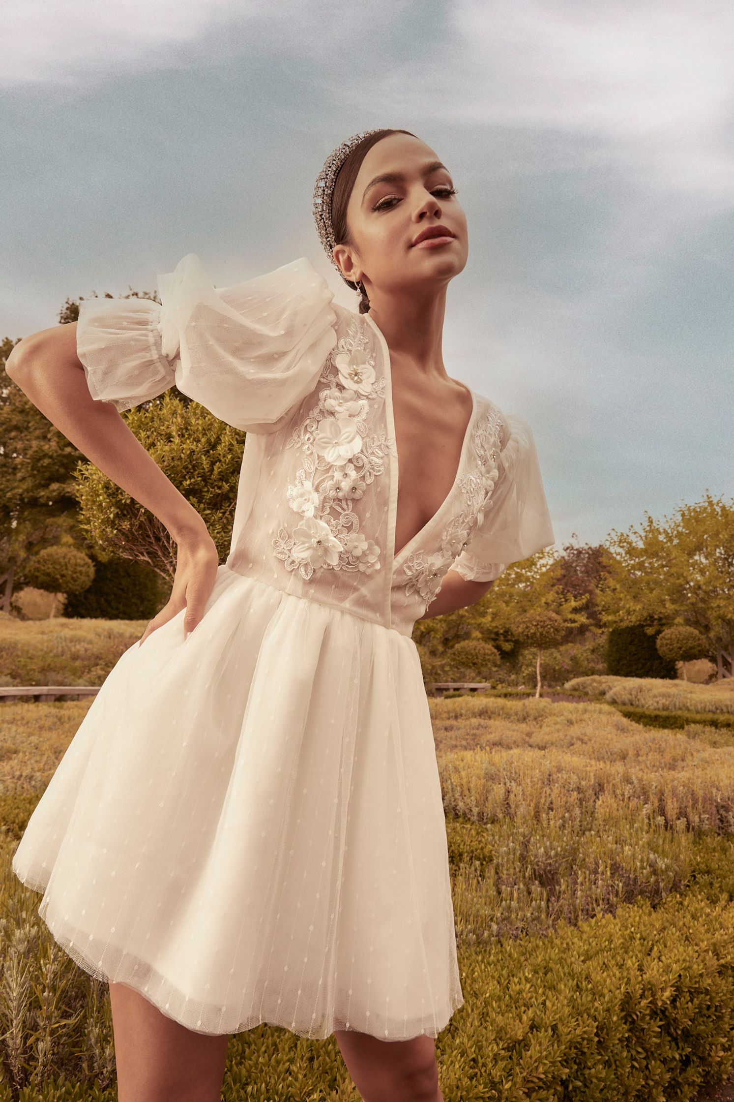 a woman in a white dress posing in a field