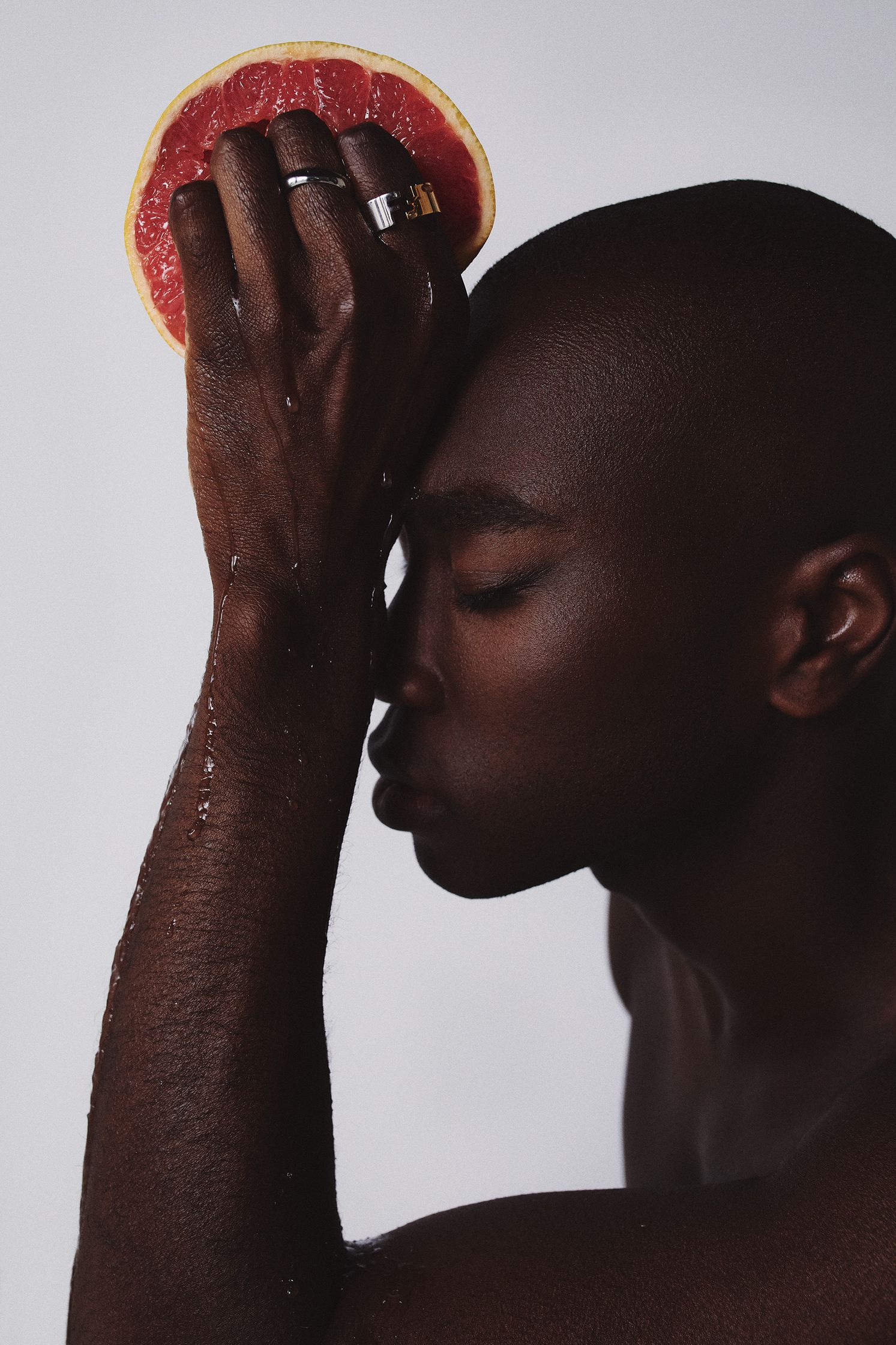 a man with a slice of grapefruit on his head