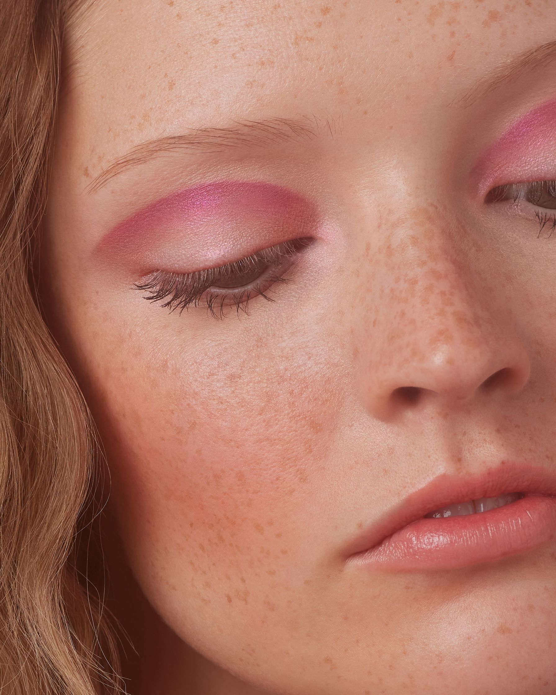 a close up of a woman with pink eye makeup