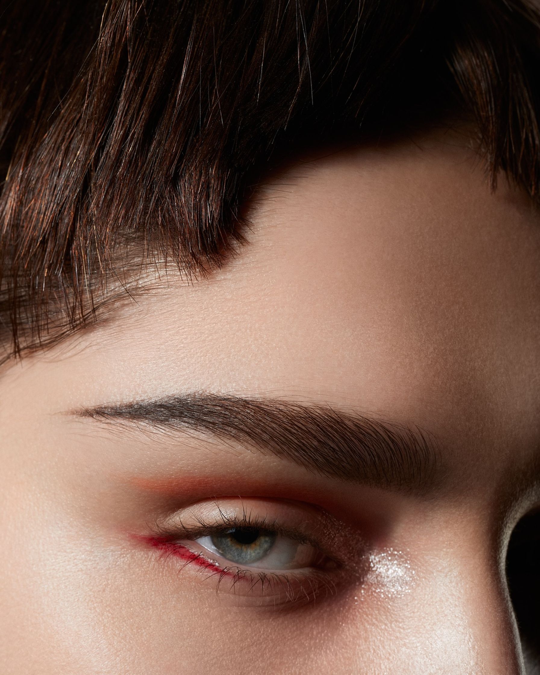 a close up of a woman's eye with red makeup