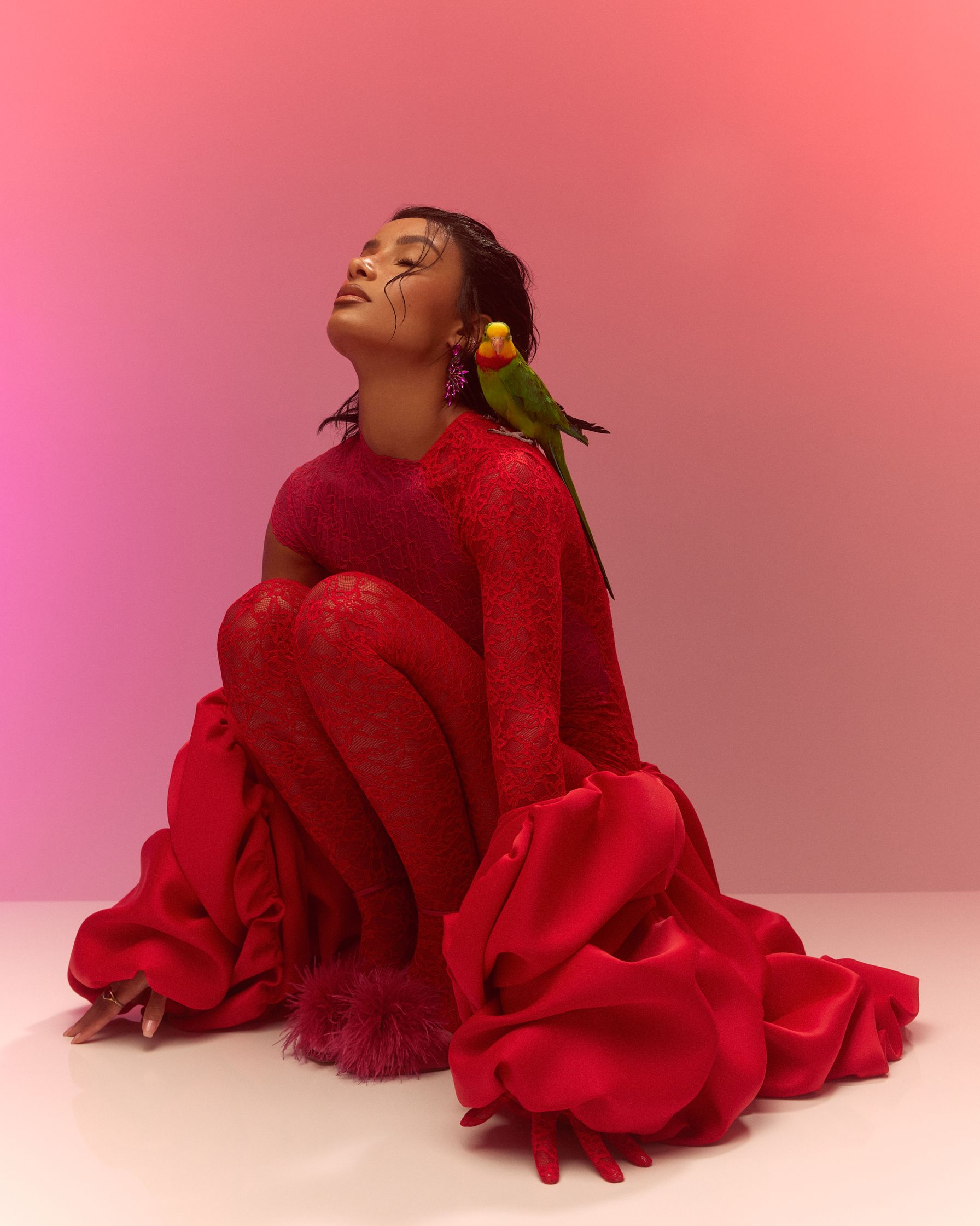 a woman in a red dress with a parrot on her shoulder