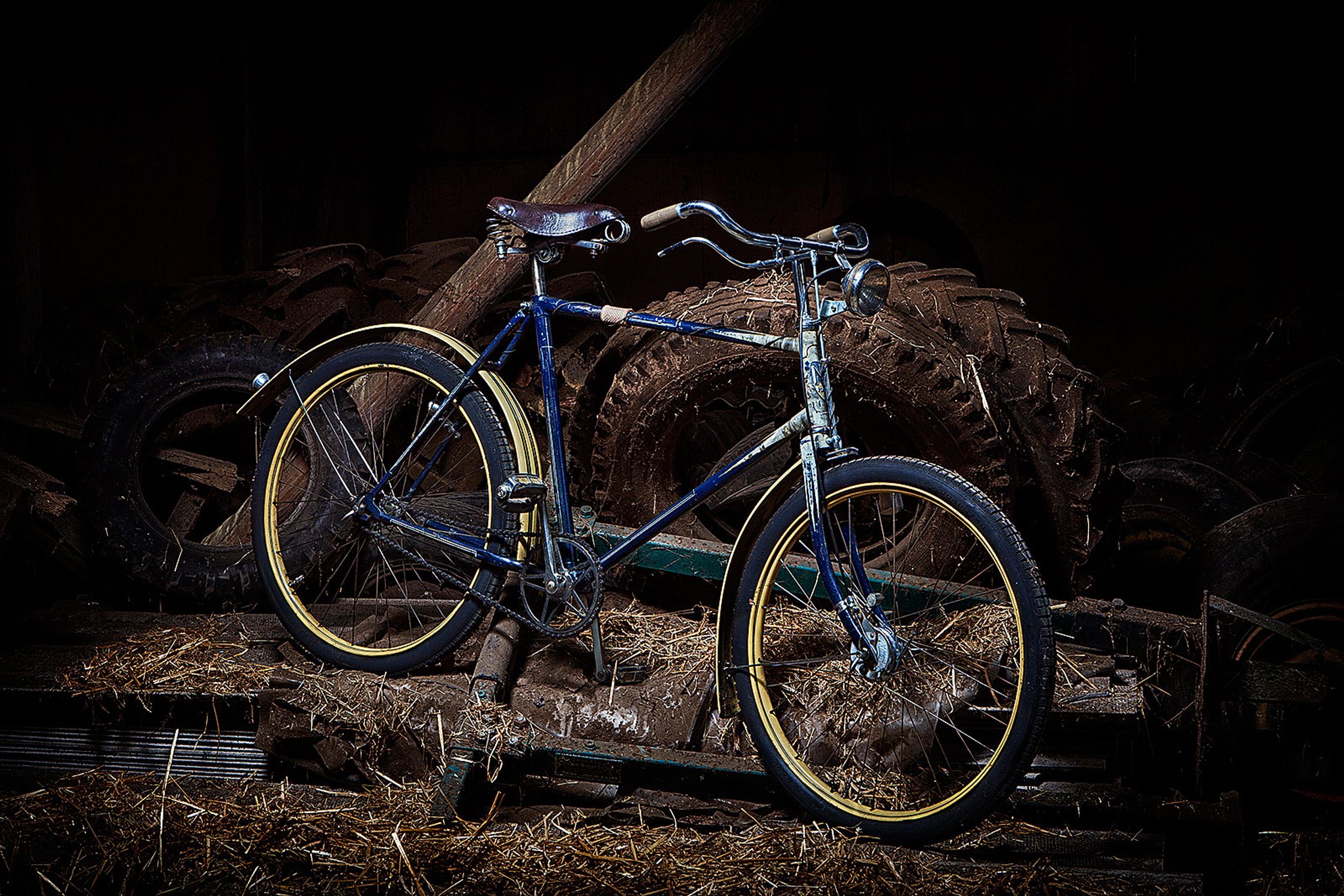 a old bicycle parked on a pile of hay Bildbearbeitung Hamburg