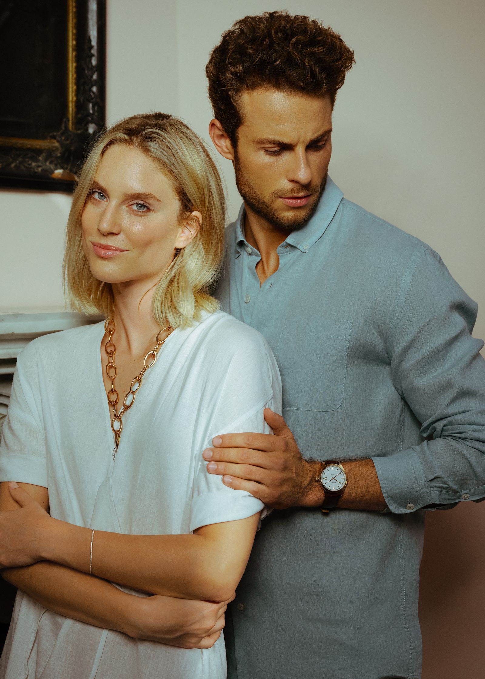 a man and woman standing in front of a fireplace