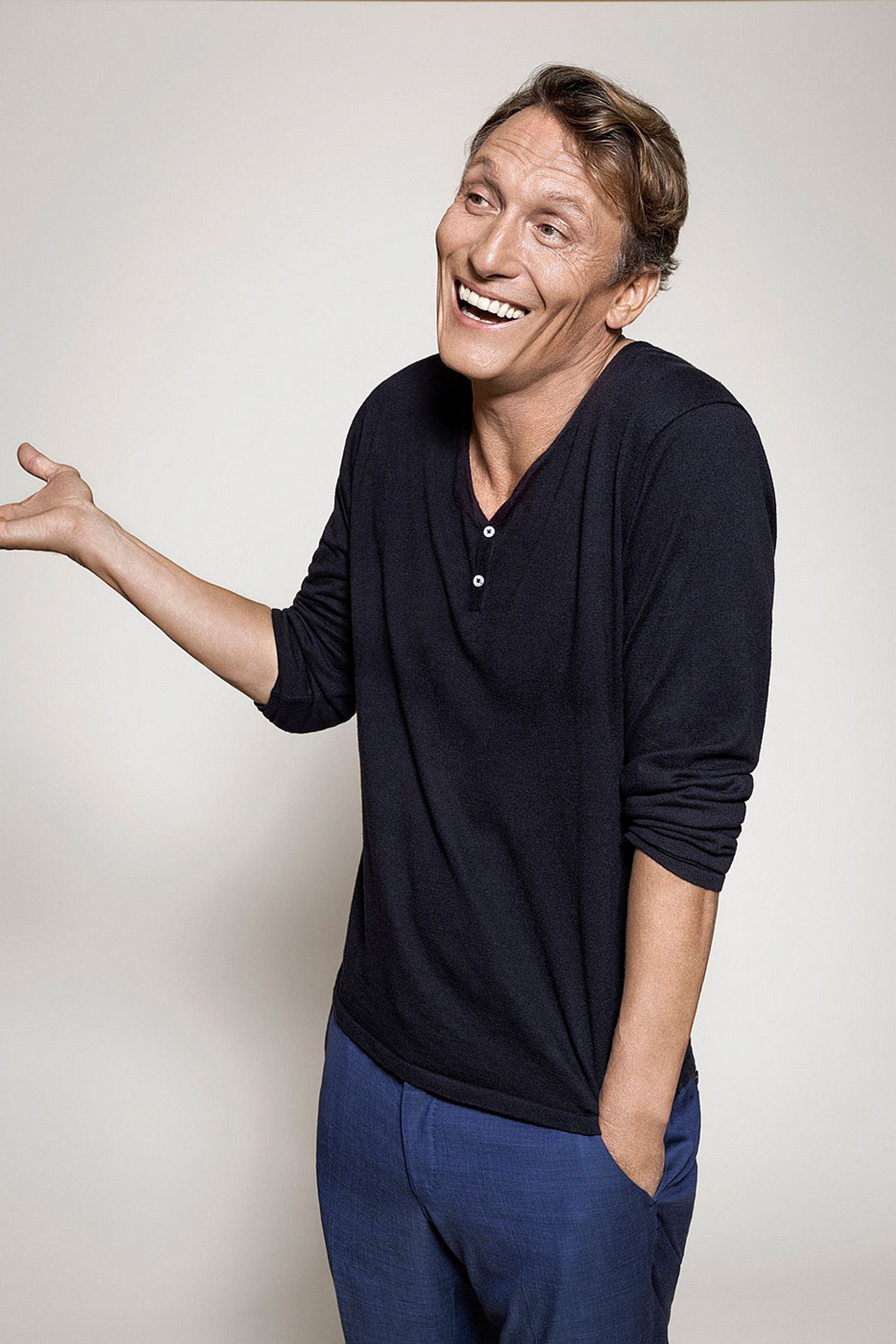 a smiling oliver masucci in a black shirt and blue pants
Bildbearbeitung by glamtouch