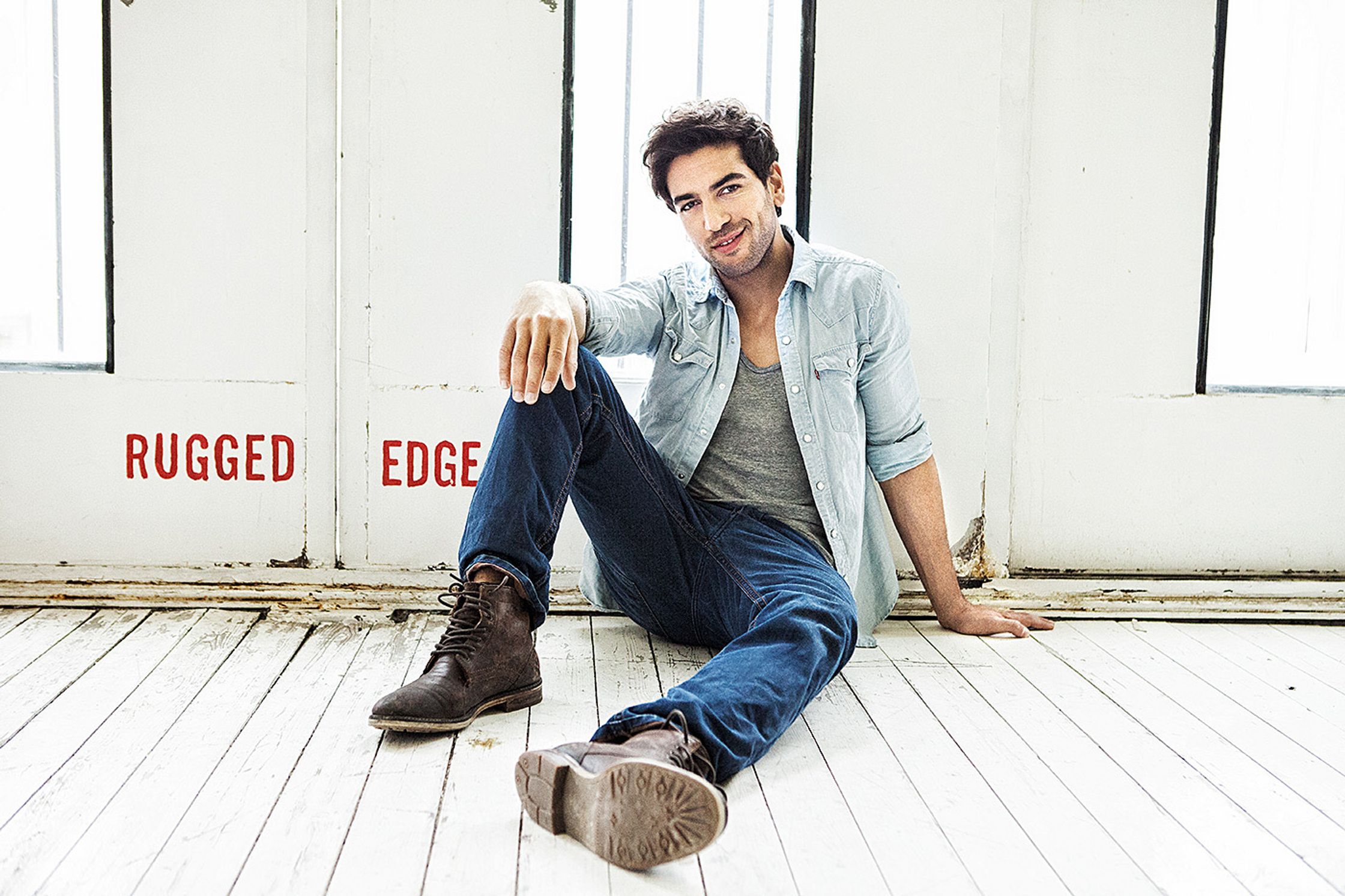 elyas m'barek sitting on the floor with the words rugged edge
retusche by glamtouch