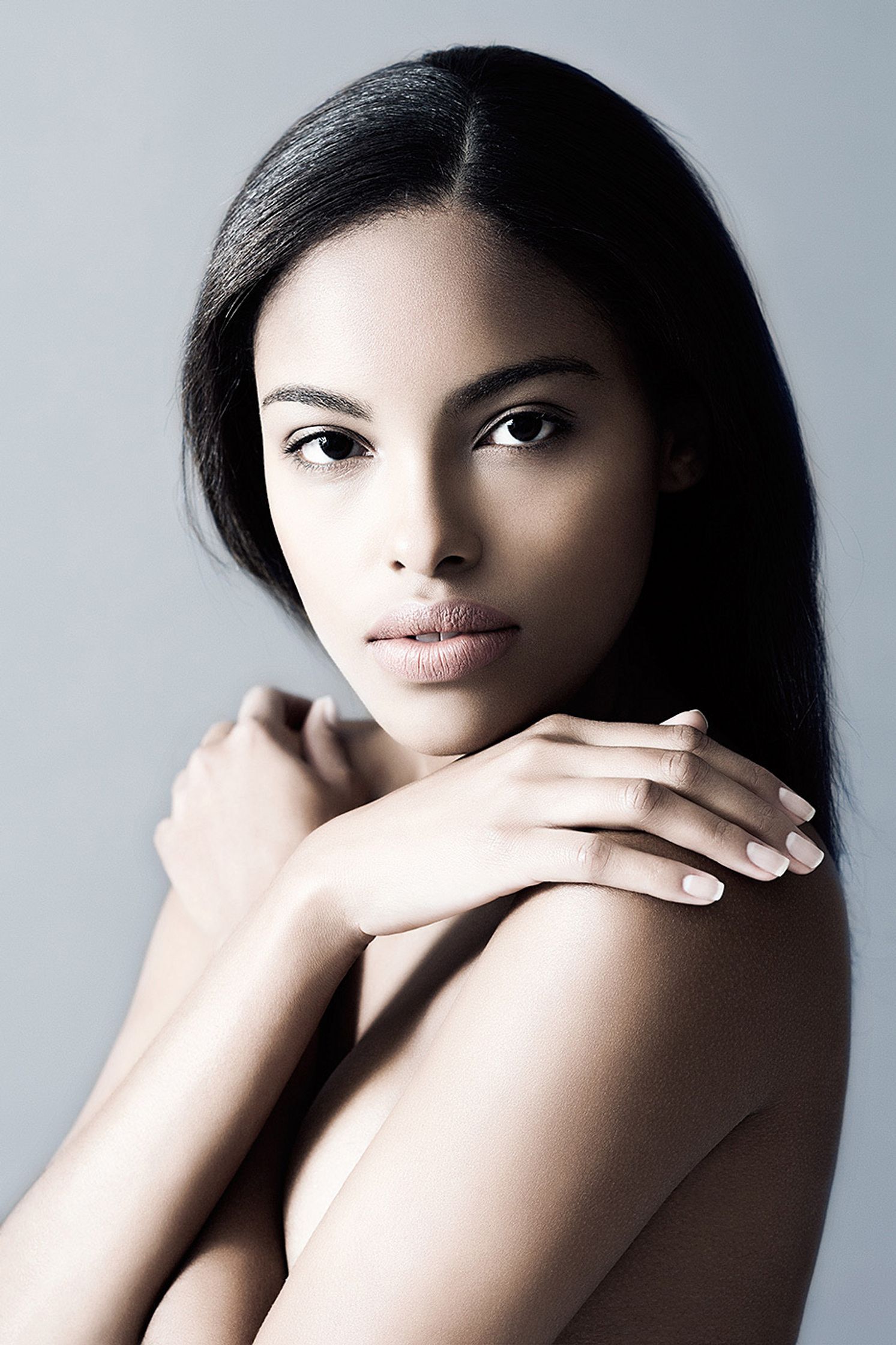 a young black woman posing with her hands on her chest beauty post production