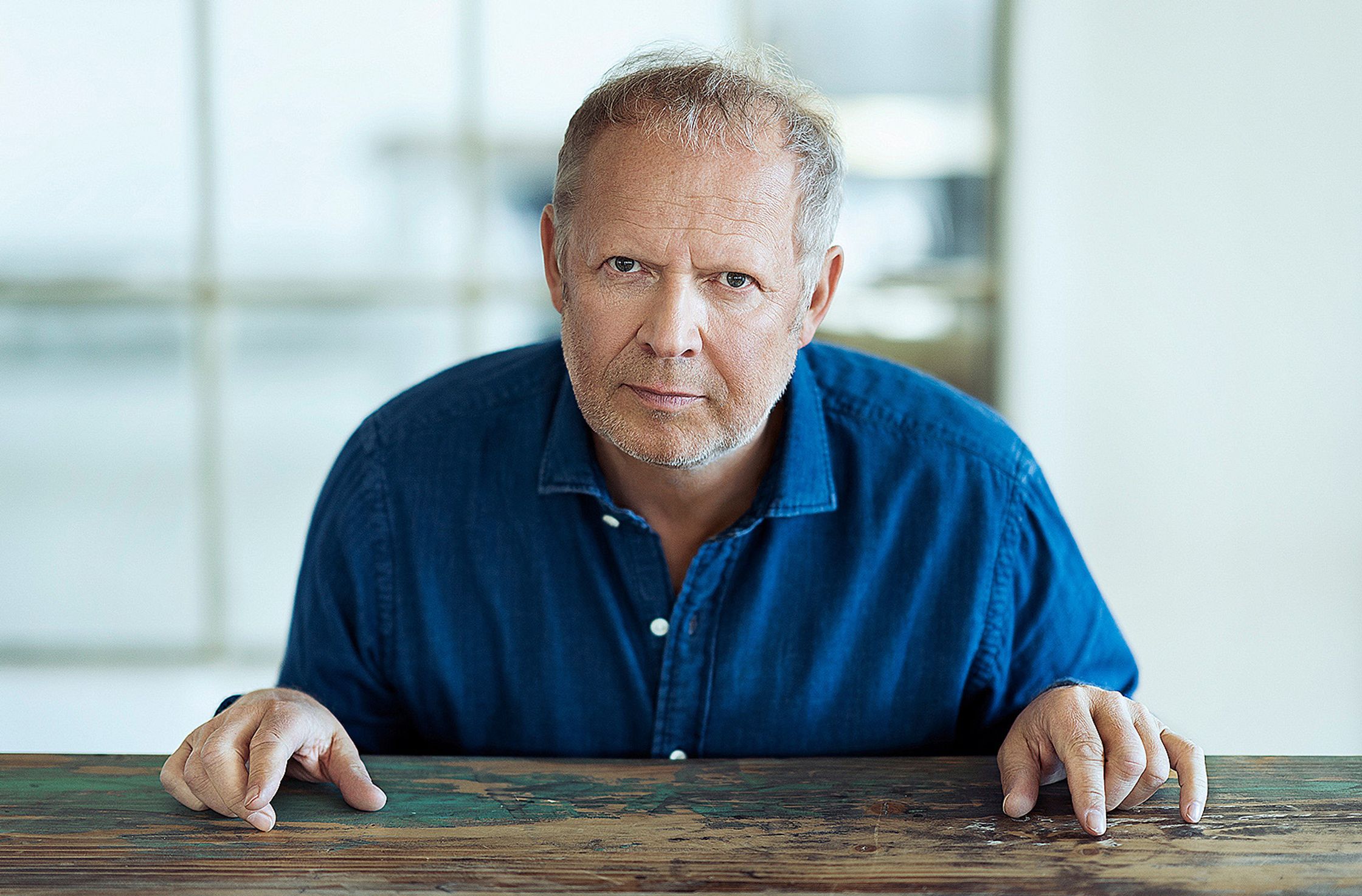 axel milberg sitting at a table with his hands in his pockets
Retouch - Bildbearbeitung Hamburg