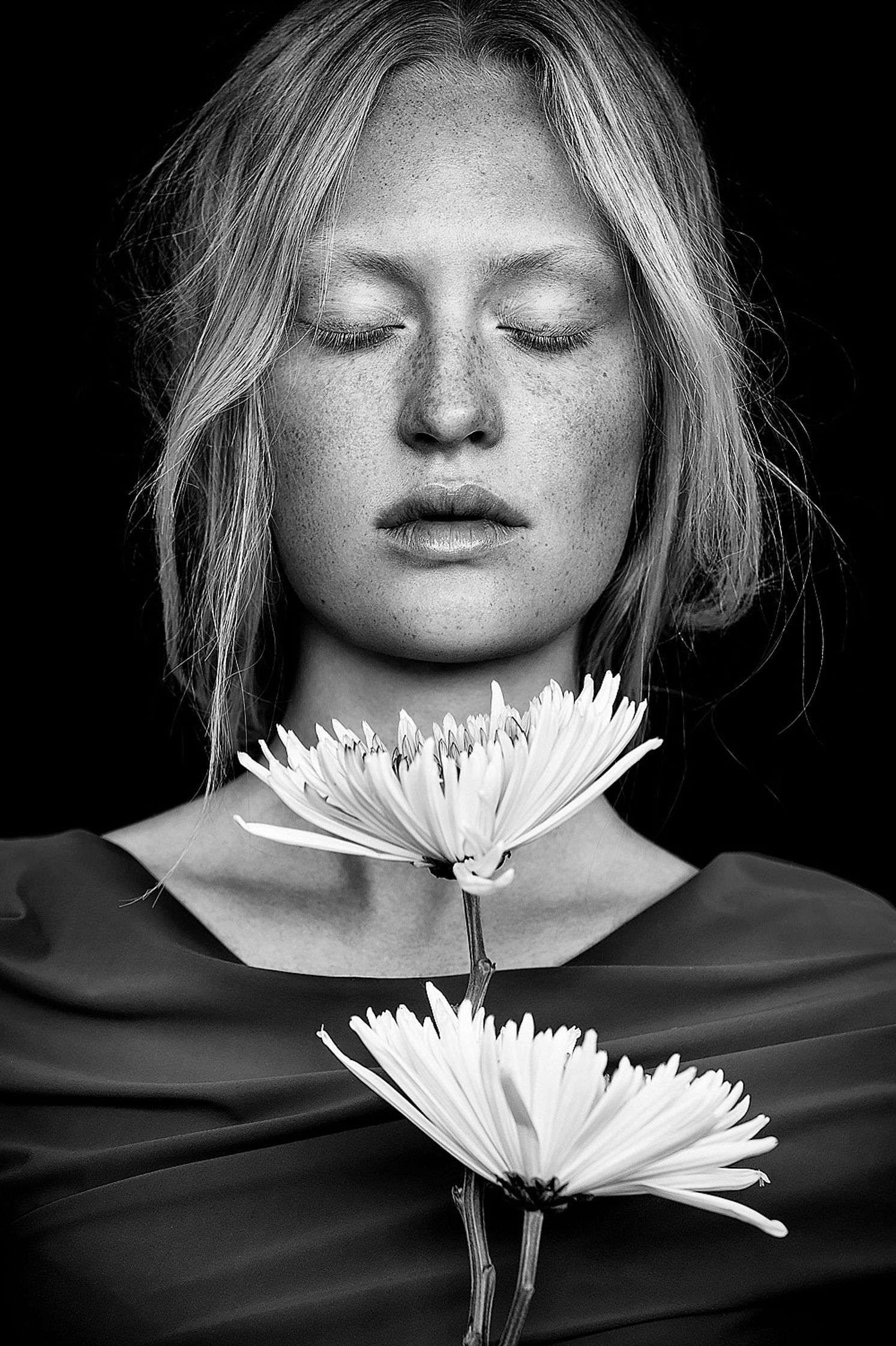 a black and white photo of a woman holding a flower natural retouch campaign