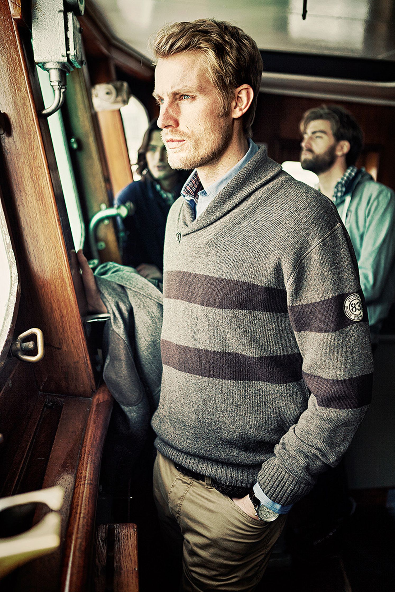 a man wearing a sweater on a boat Bildbearbeitung calamar fashion kampagne