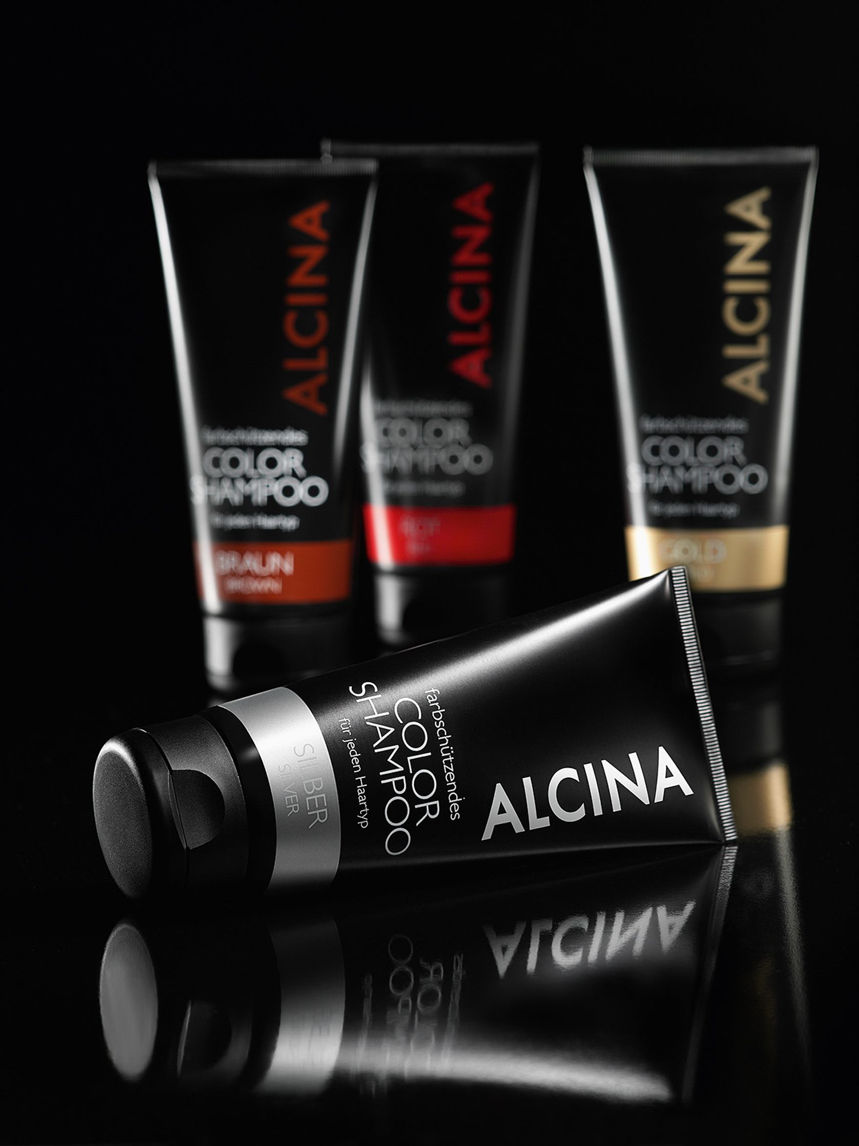 three tubes of alcina hair color on a black background Post Production