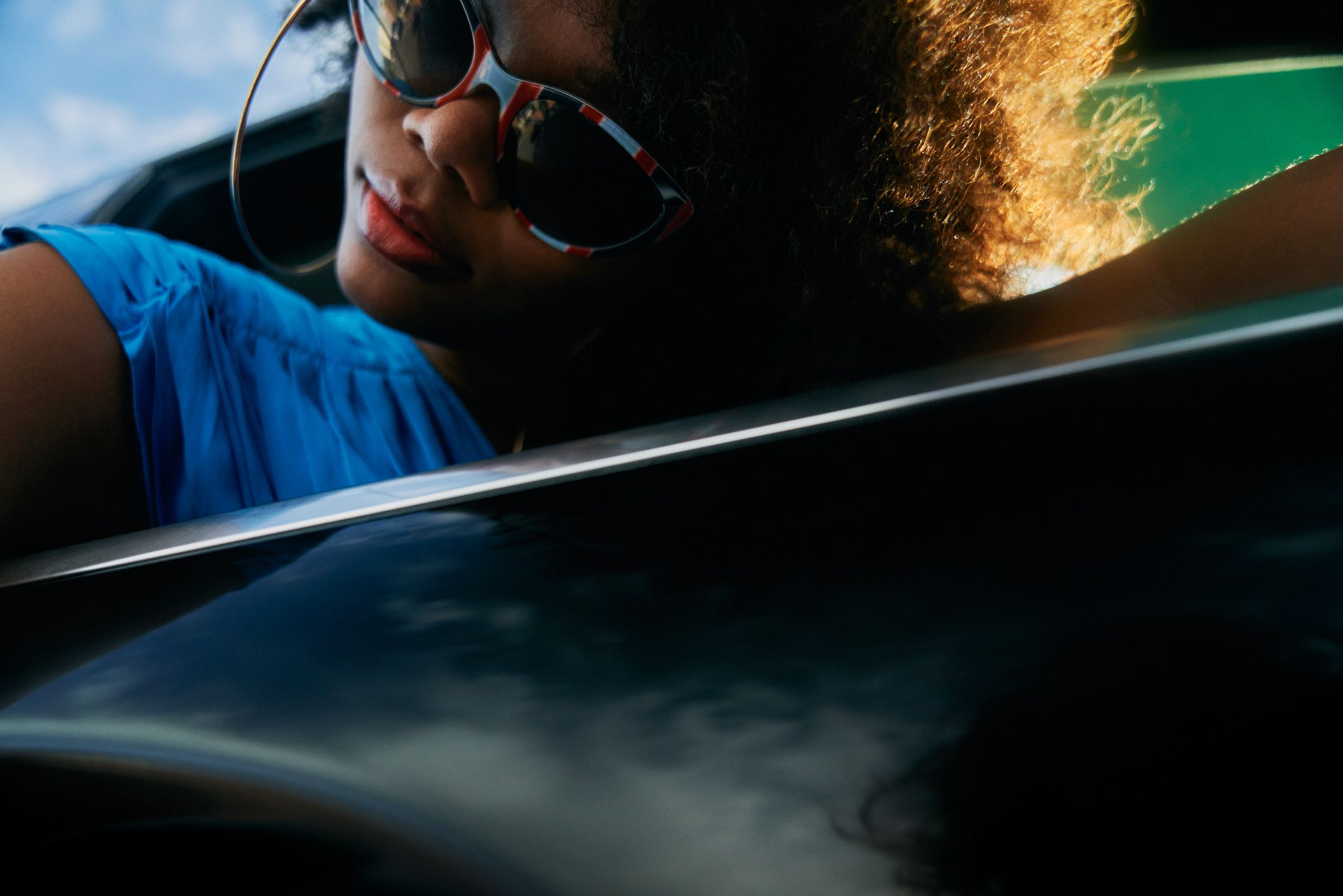 a woman wearing sunglasses in the back seat of a car